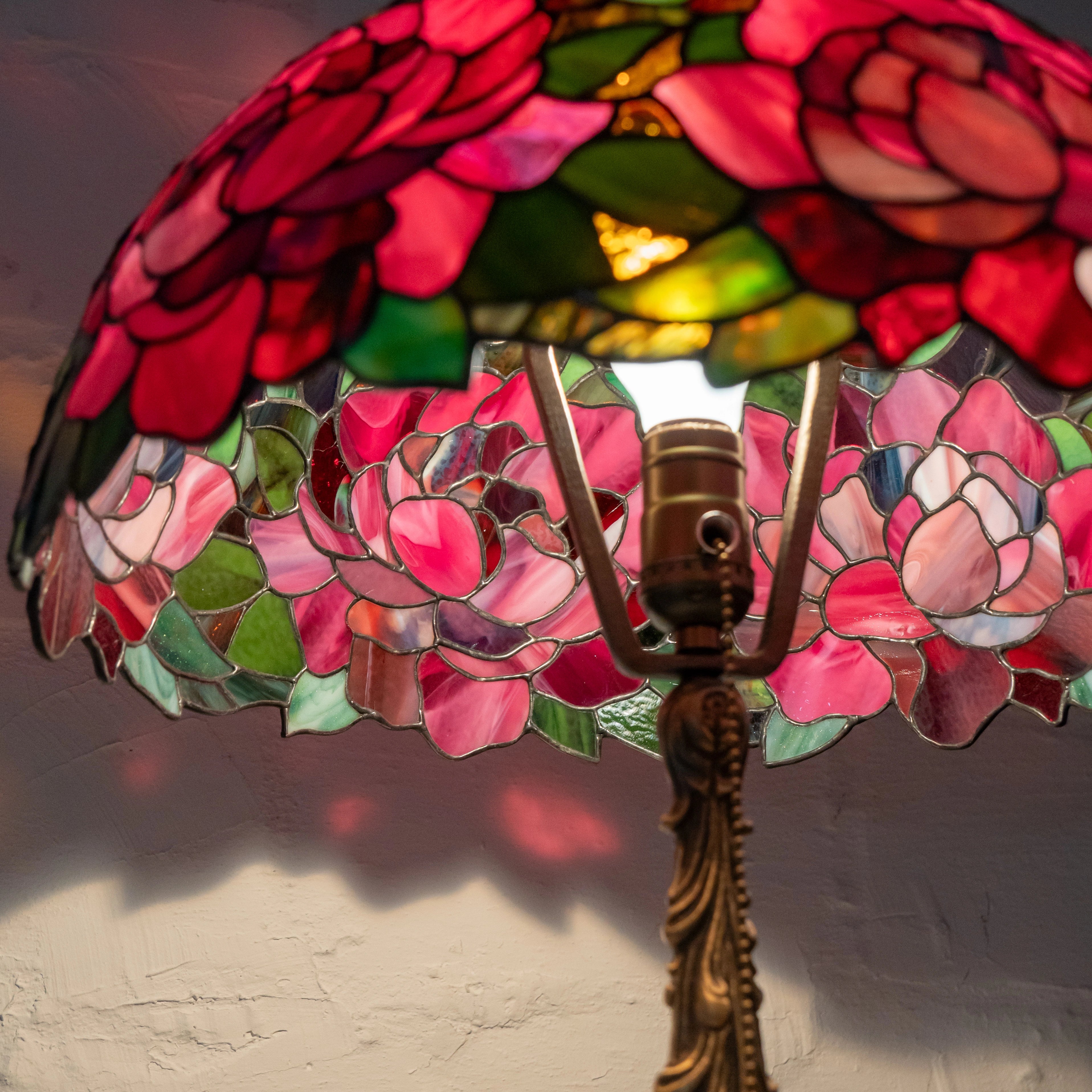 Inside view of stained glass peony lamp with glowing petals and leaf details – floral glass lamp interior close-up