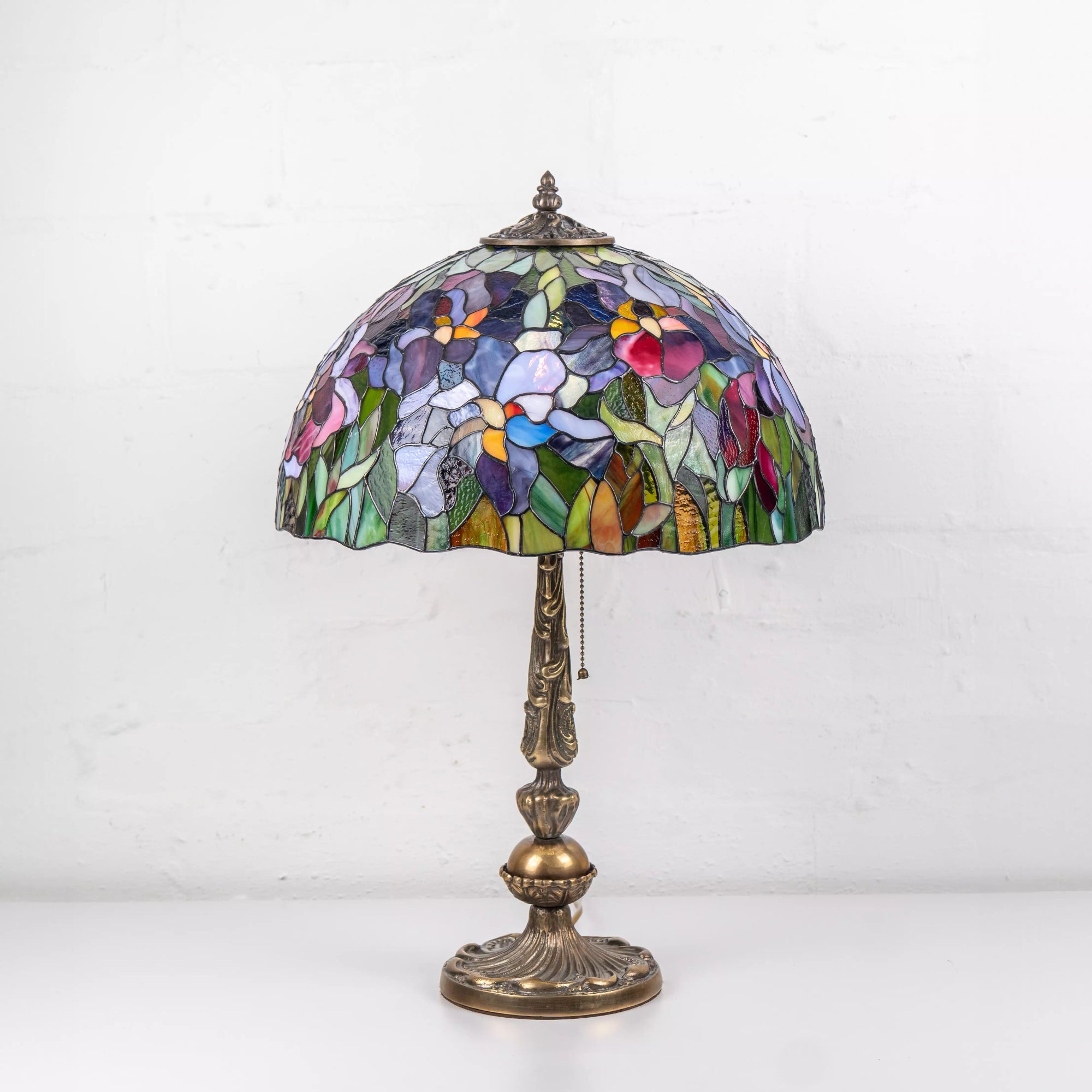 Daylight view of floral stained glass lamp with purple, red and green elements