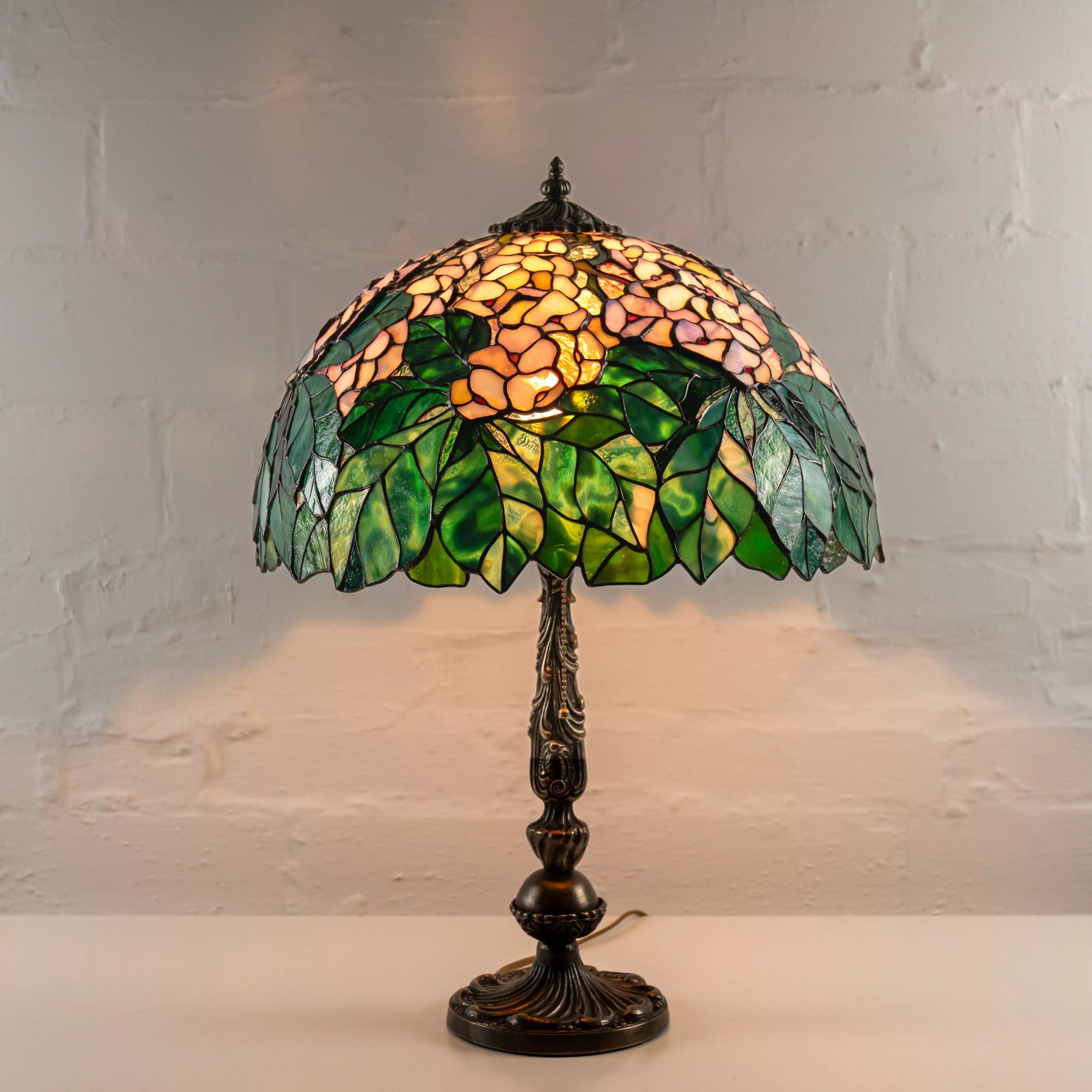 Illuminated stained glass chestnut lamp glowing warmly with leaf and flower design