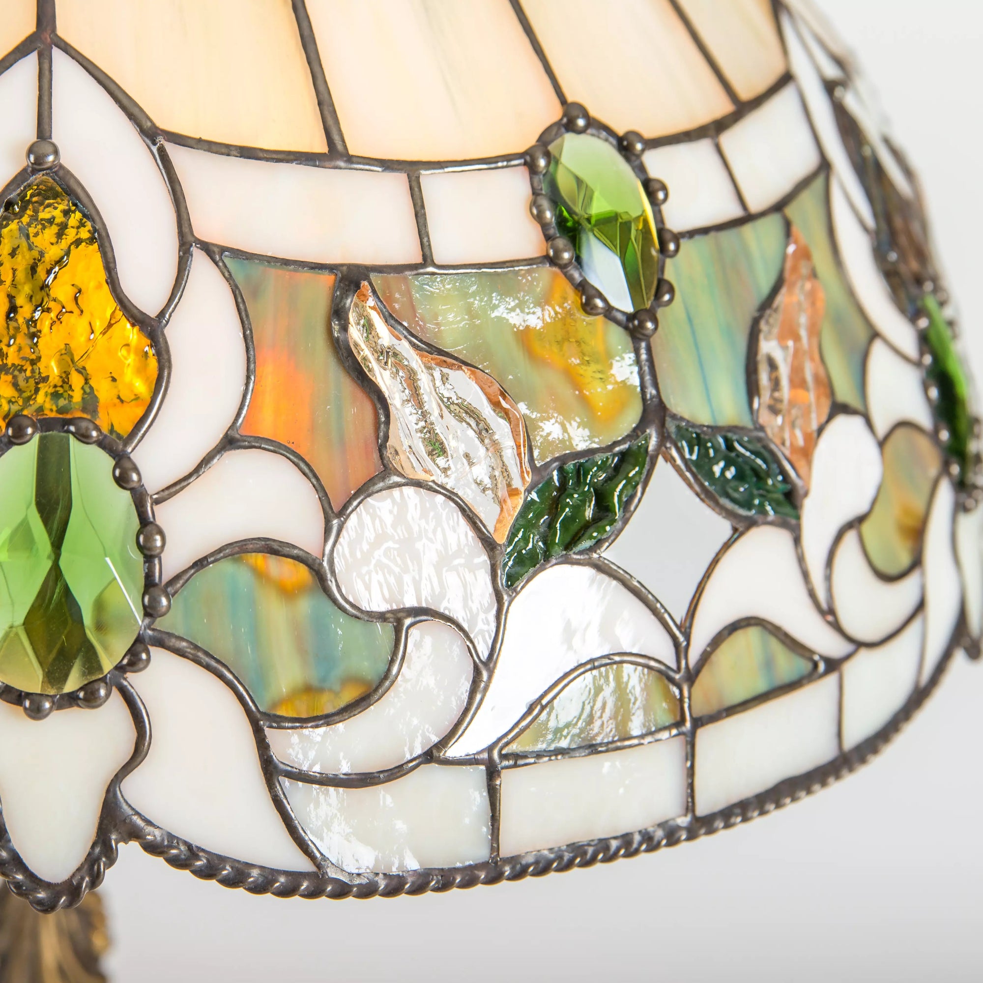 Detailed closeup of green crystals and multicolored stained glass floral sections