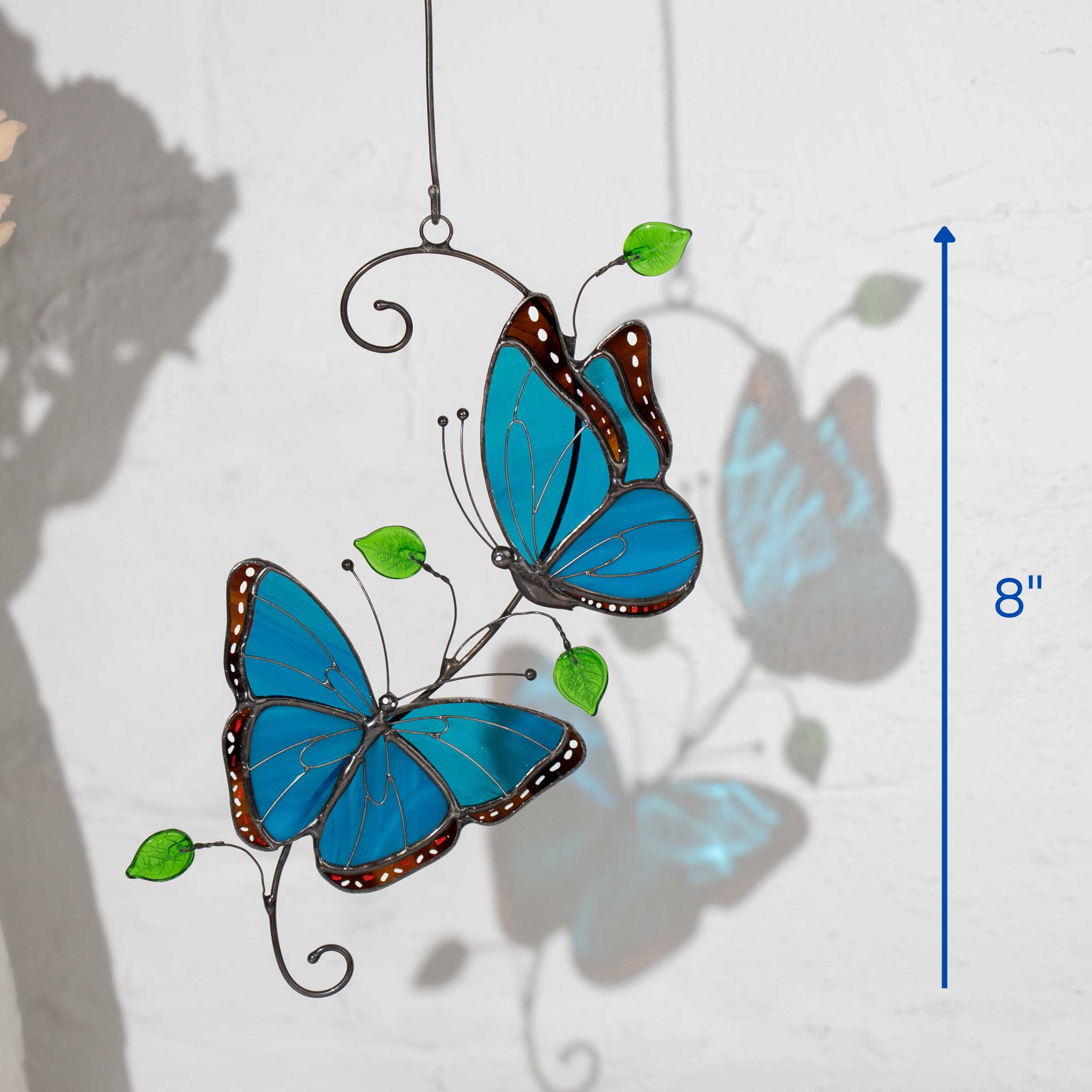 Two stained glass morpho butterflies in blue with green leaves, decorative piece shown with 8-inch size reference.