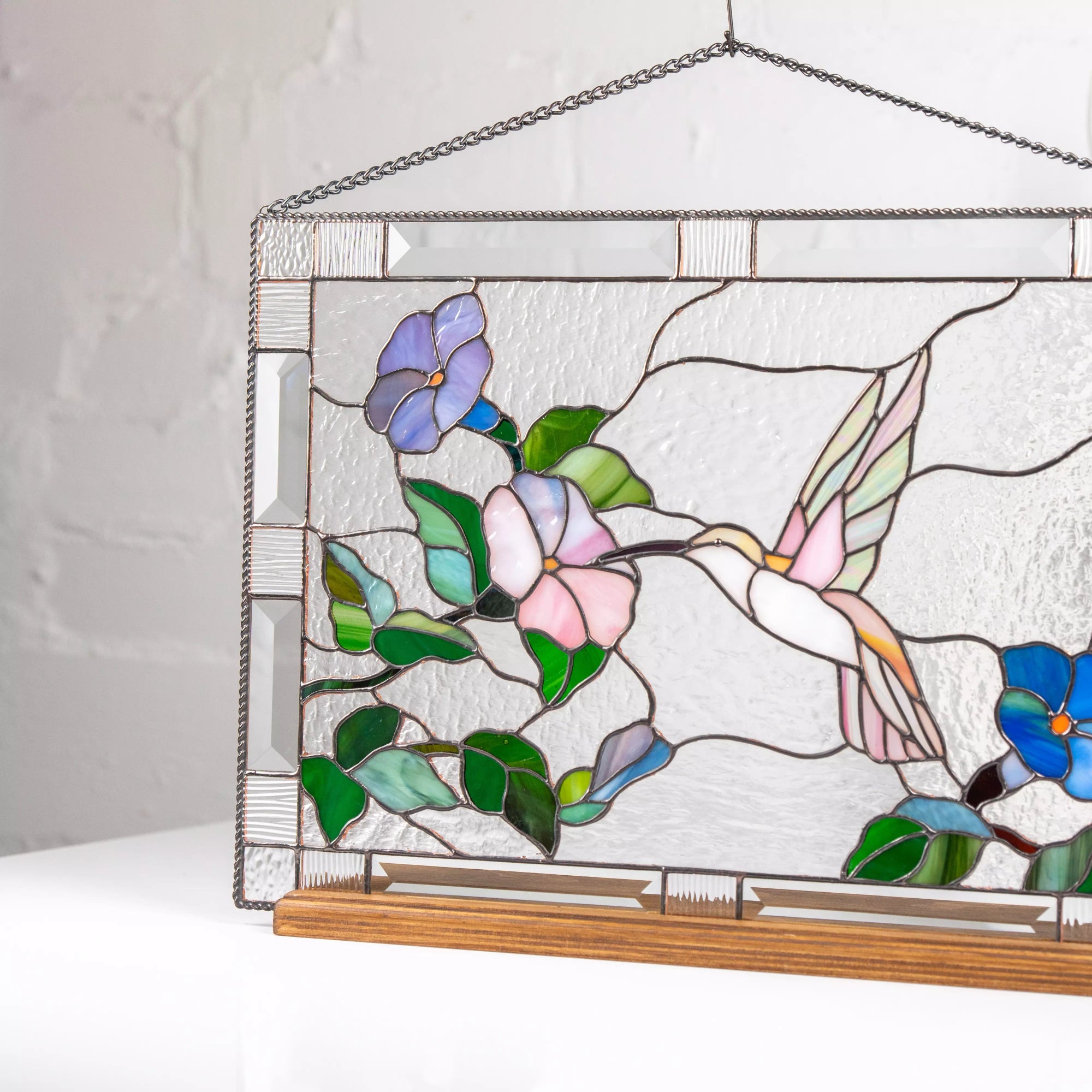 Stained glass panel with a hummingbird and flowers on a wood base