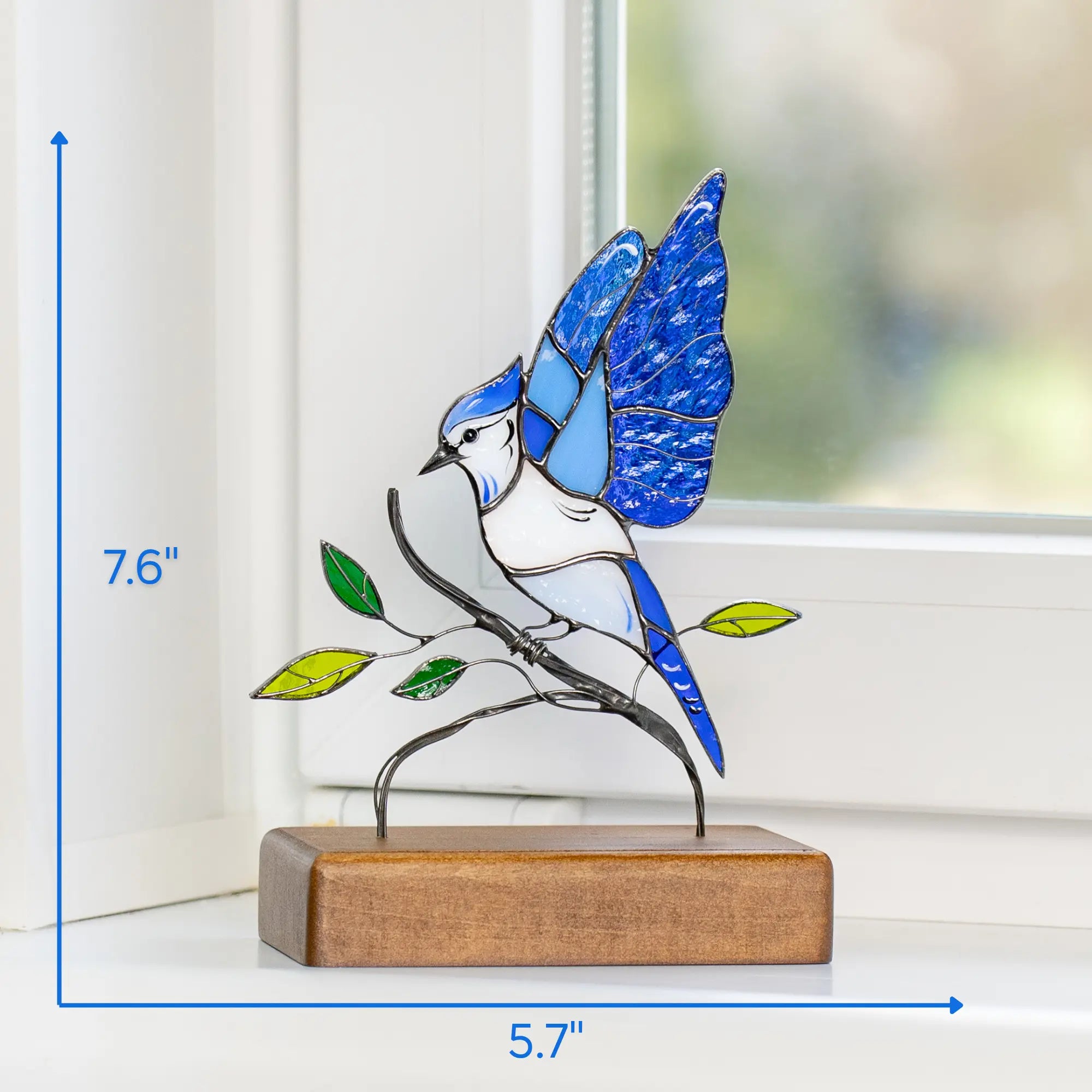 Blue jay stained glass sculpture shown with size indicators next to window for scale