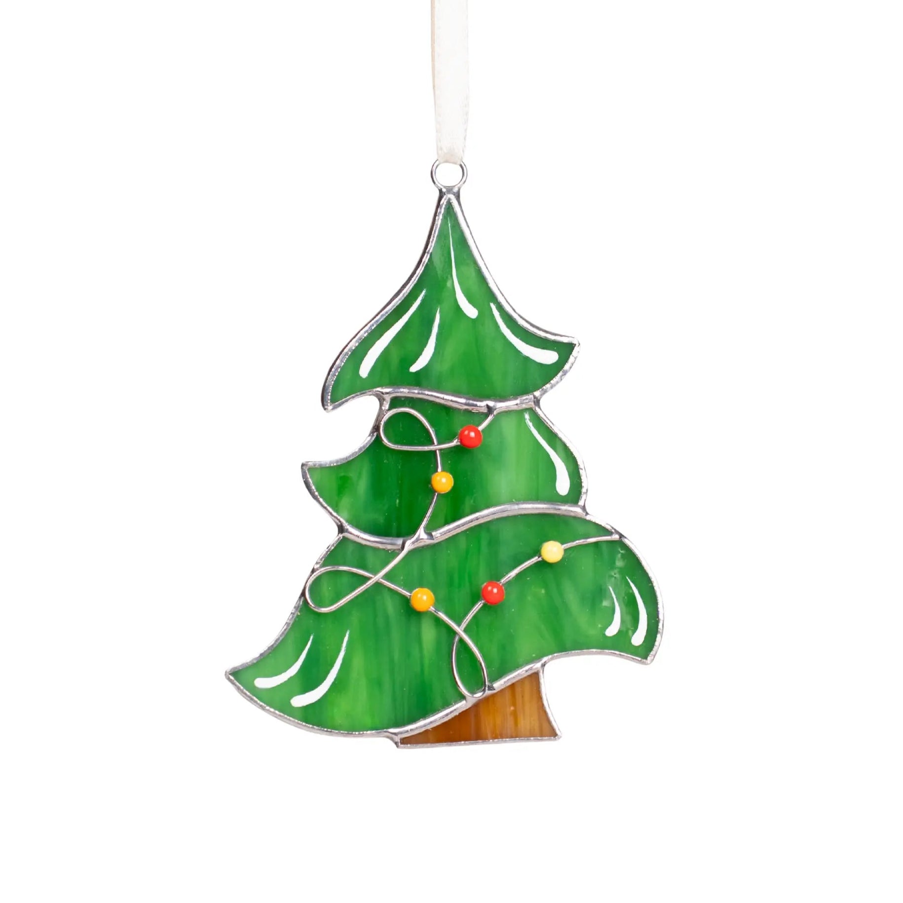 Green stained glass Christmas tree suncatcher with red, yellow, and orange lights in garland, hanging on a white ribbon.