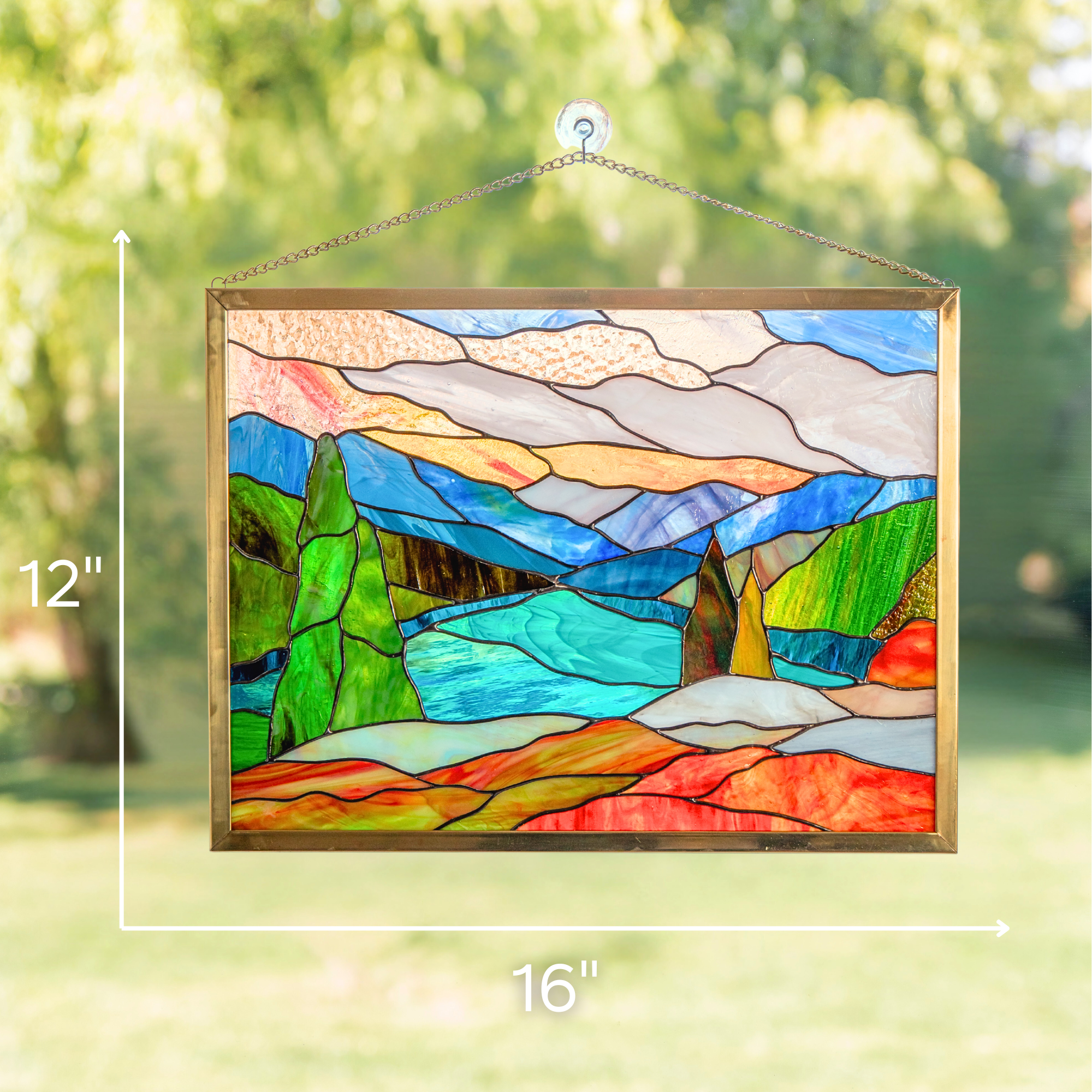 Mount Rainier stained glass panel with measurements 16" x 12" against sunny garden background