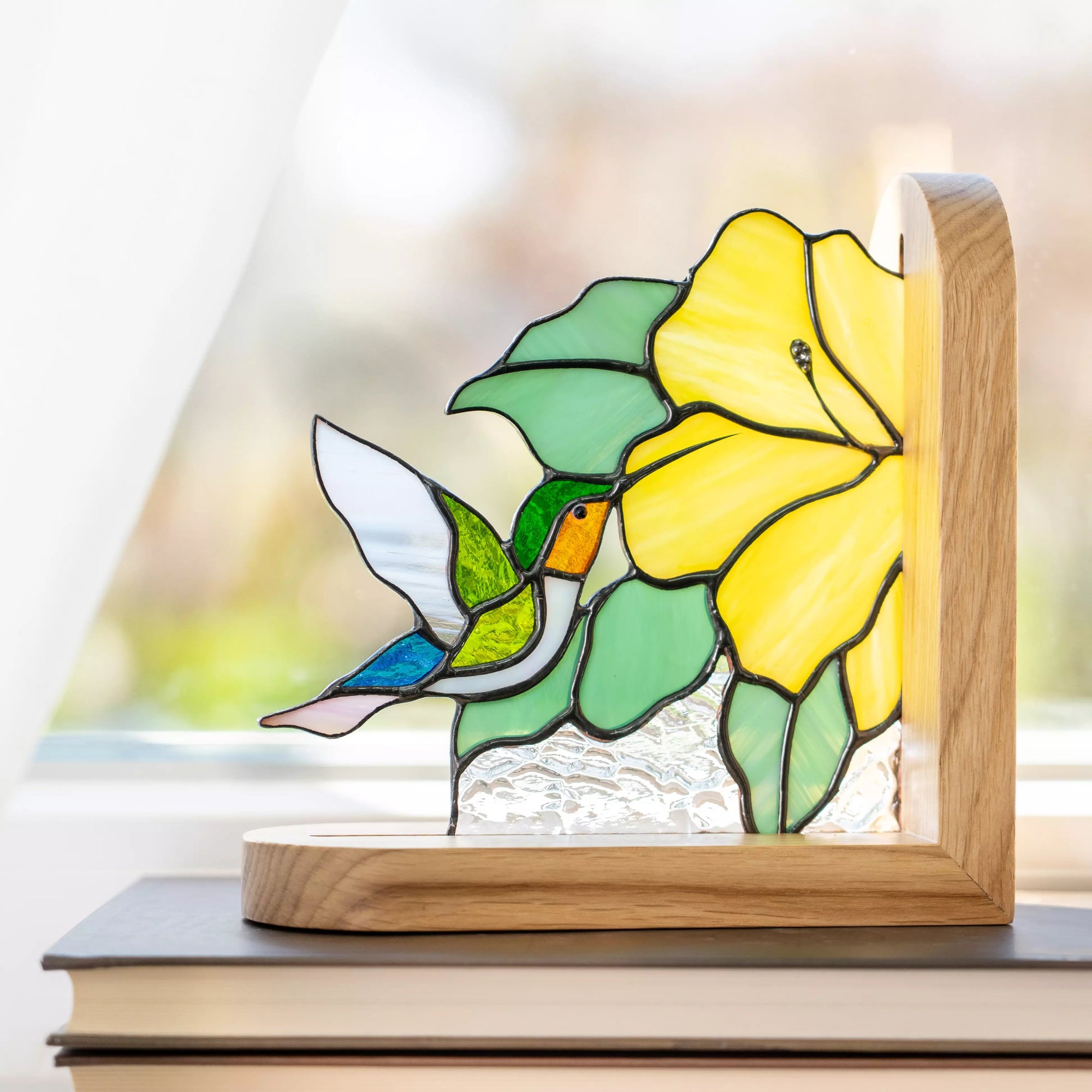 Close-up of stained glass bookend panel leaves and yellow flower detail on hummingbird bookend