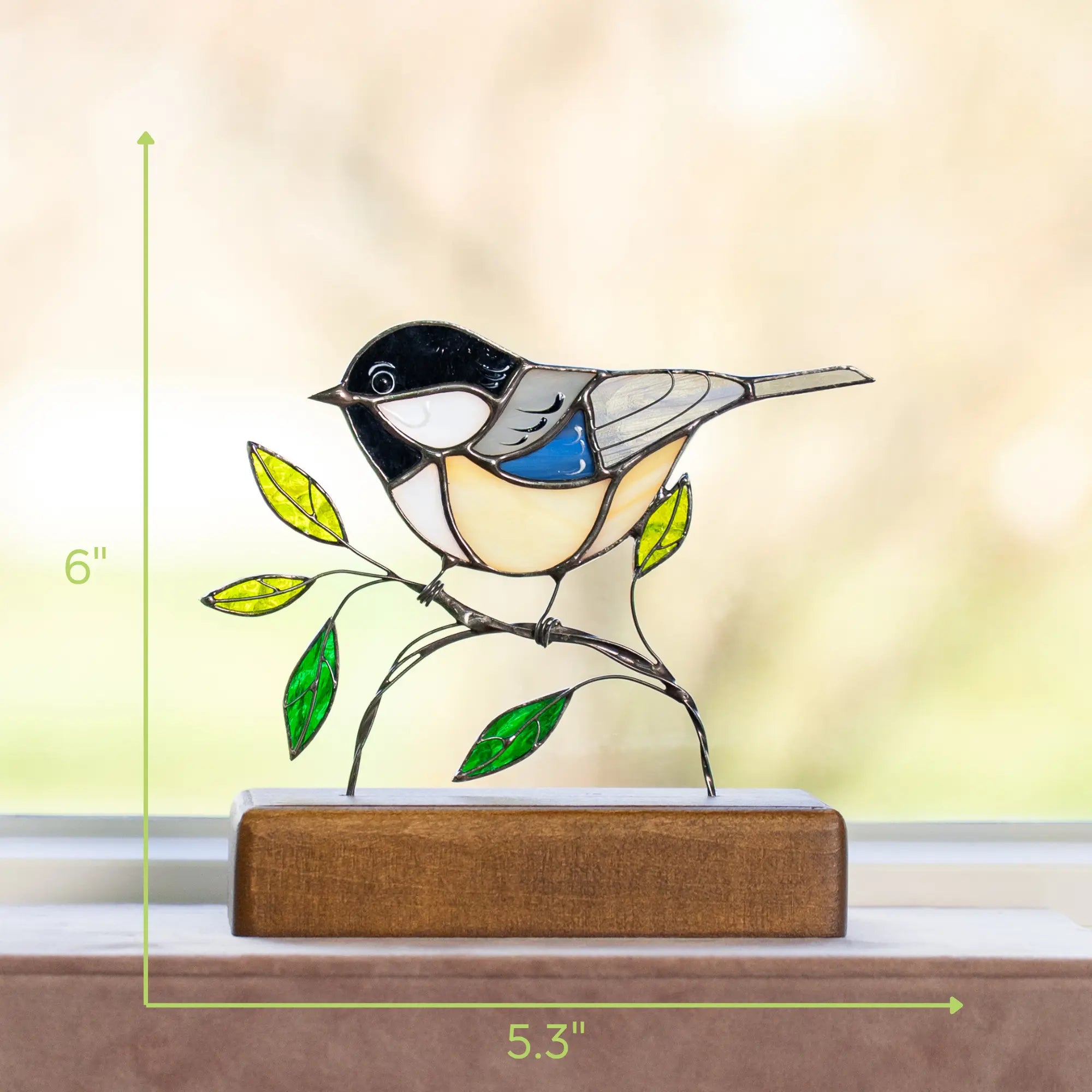 Chickadee stained glass suncatcher with green leaves on the wooden base and size measurements shown