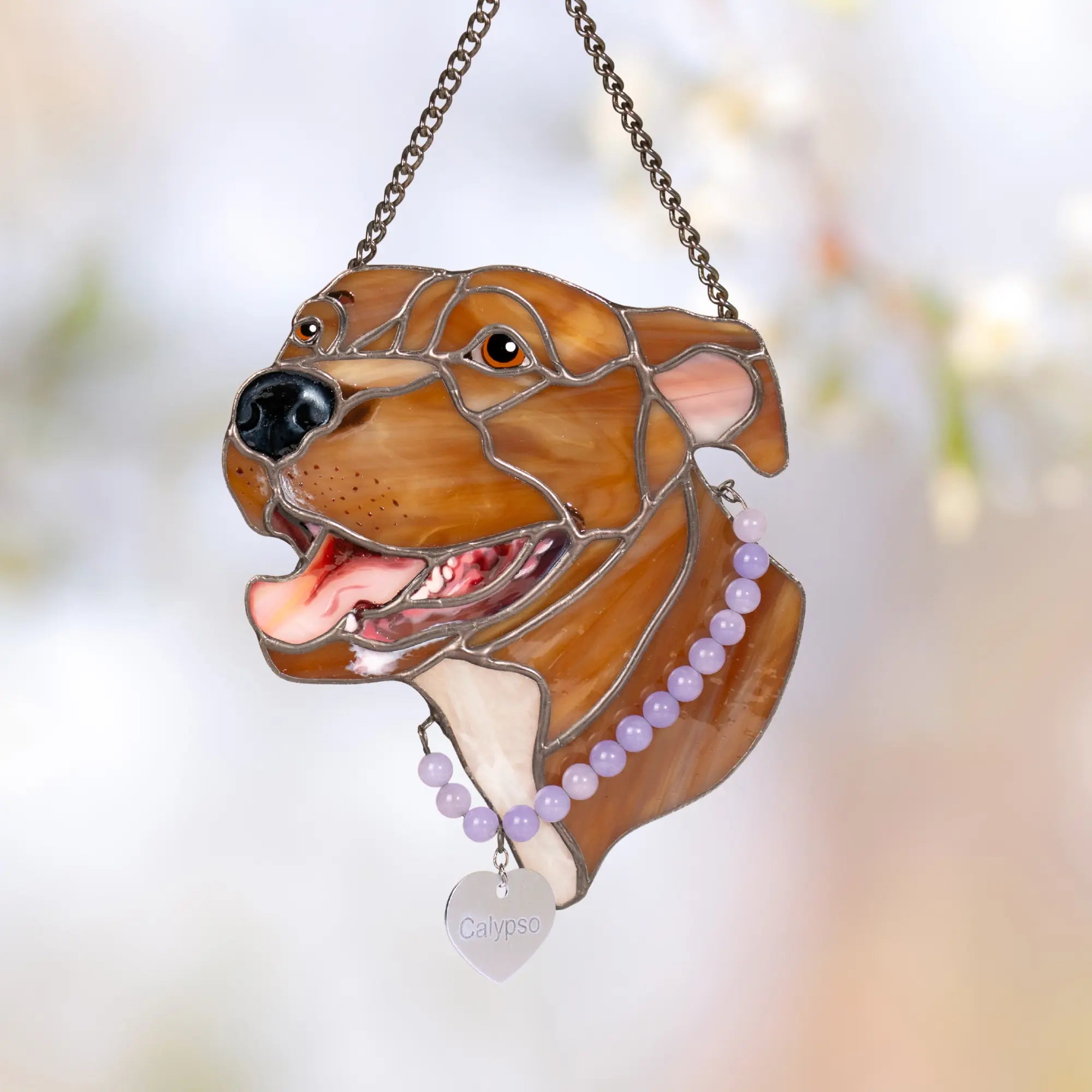 Stained glass suncatcher pet portrait of dog with a chain and beads on a blurred background