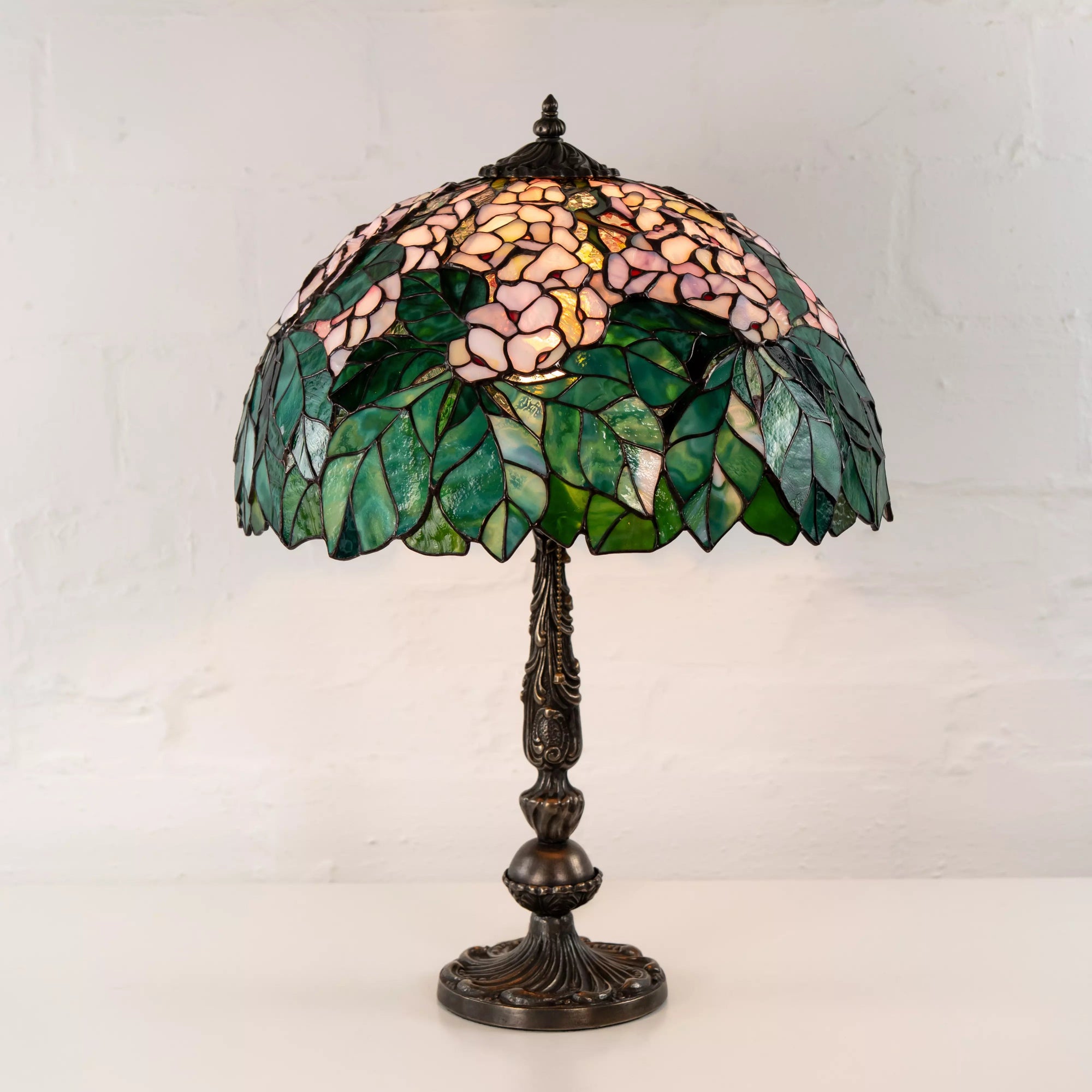 Side view of chestnut stained glass lamp with ornate bronze stand and leaf pattern