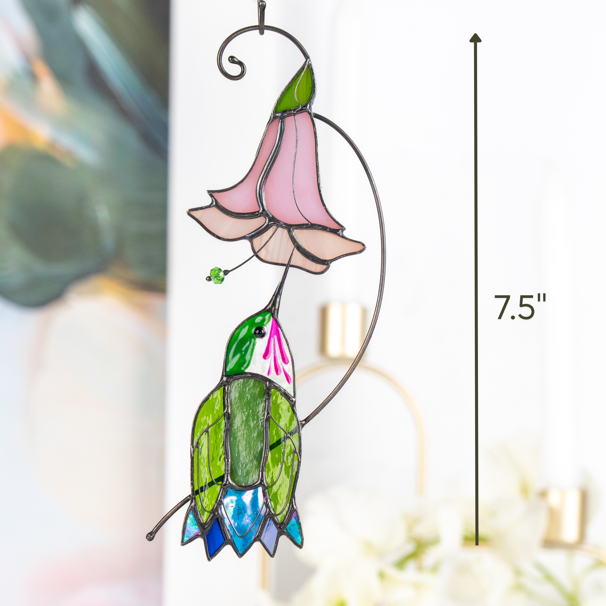 Stained glass hummingbird suncatcher with pink flower shown hanging indoors, marked with 7.5" height on right side.