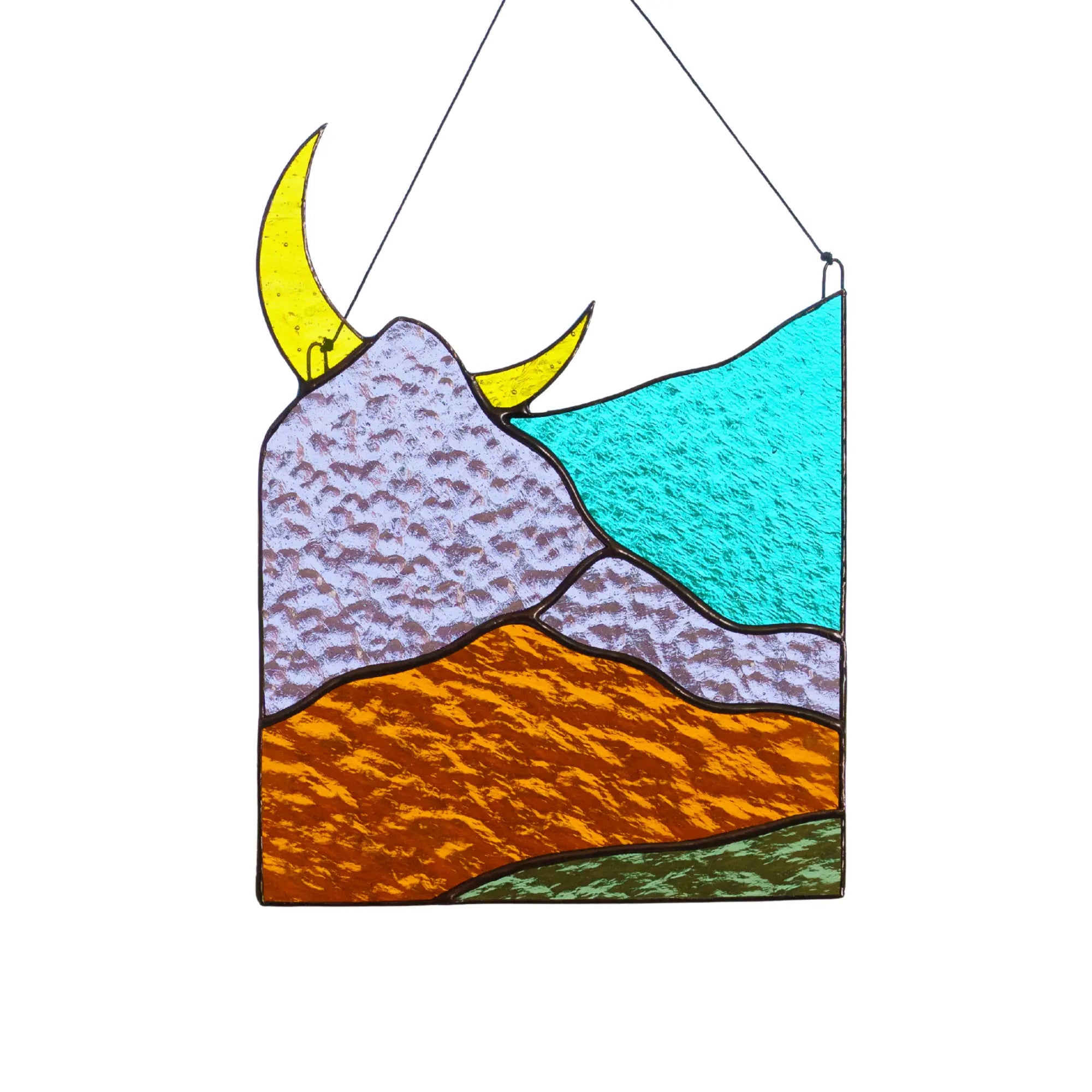 A rectangular stained glass suncatcher featuring a crescent moon rising over textured purple and orange mountains.