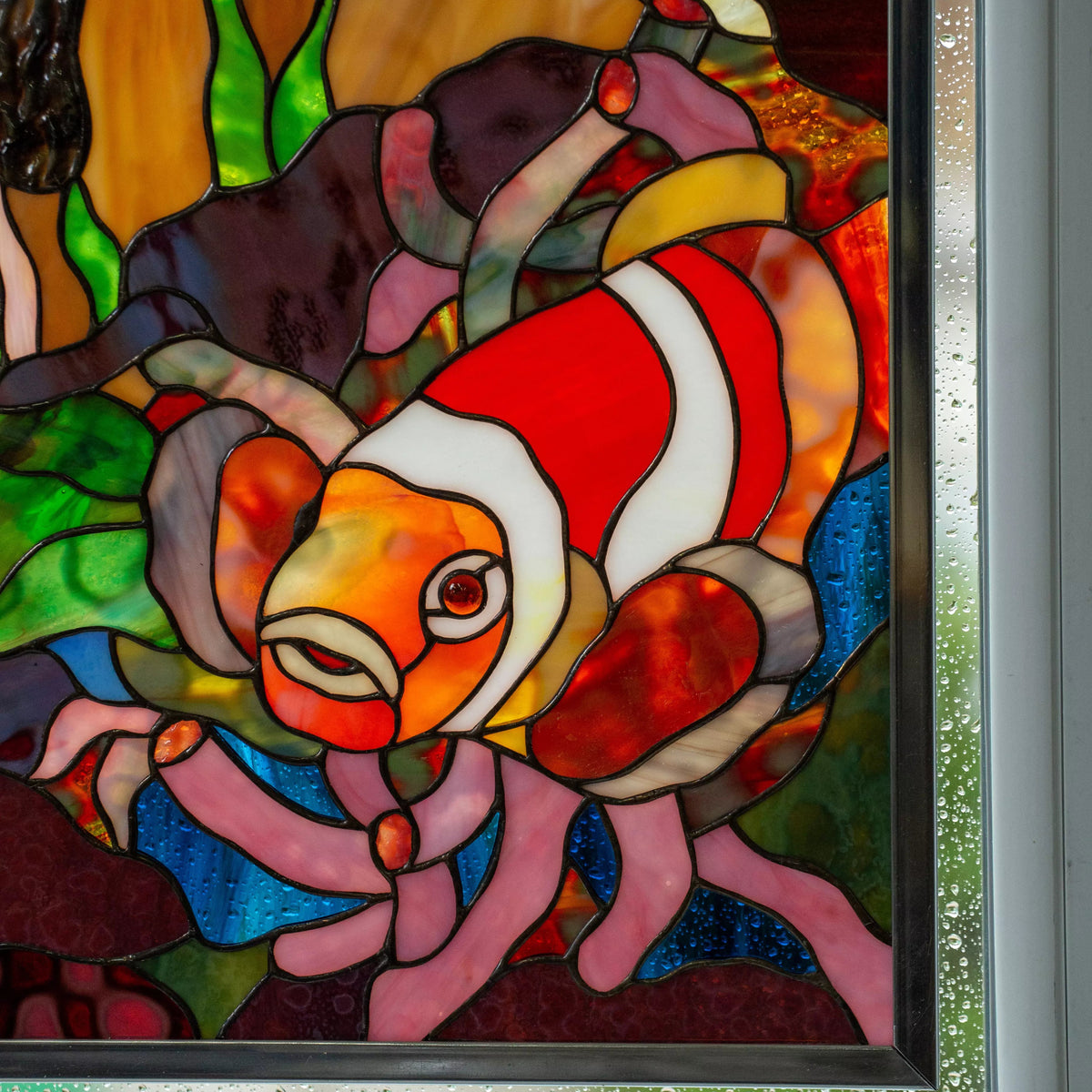 Custom handmade stained glass panel with a clownfish and coral