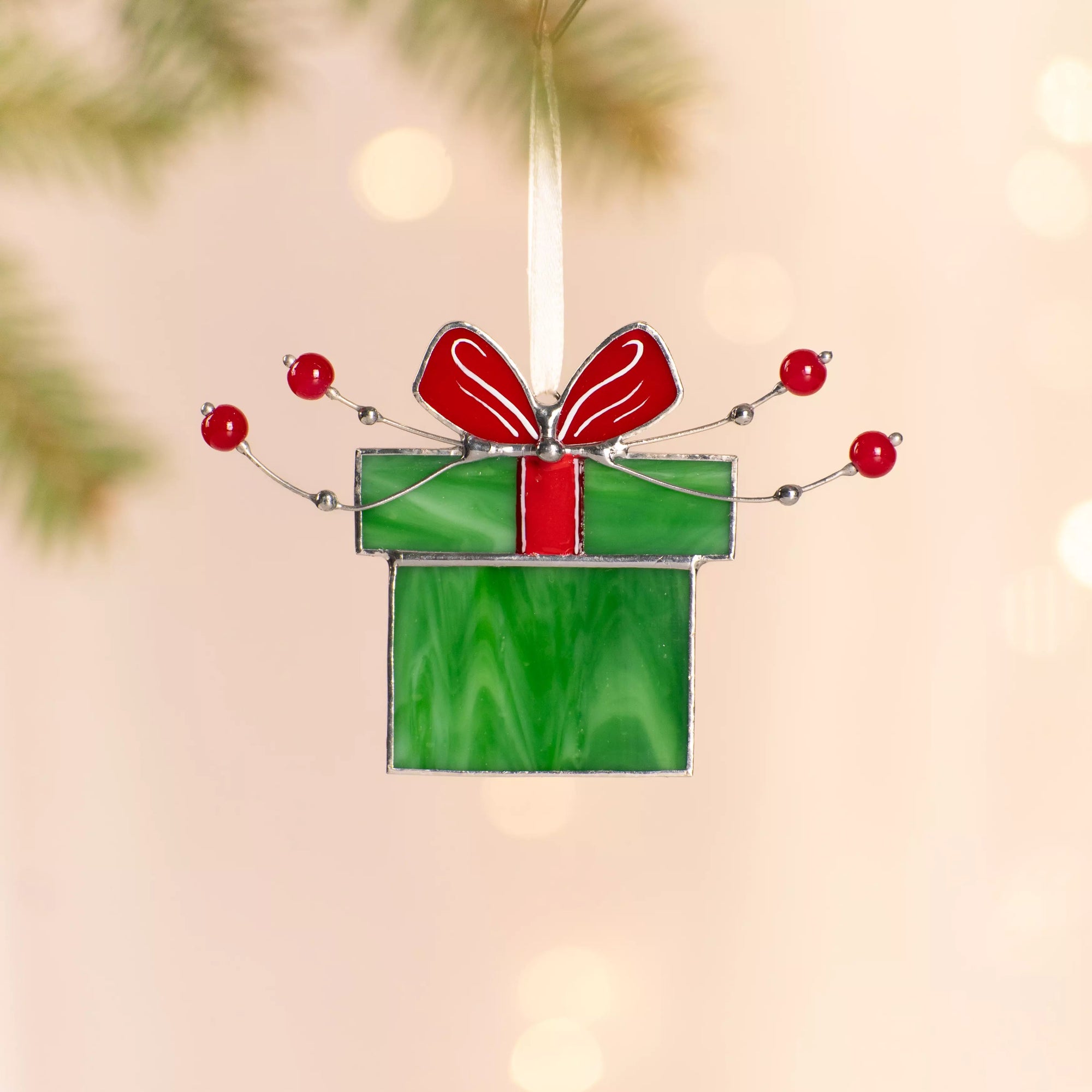 Stained glass suncatcher green gift box with a red ribbon, decorated with red beads and silver wire.