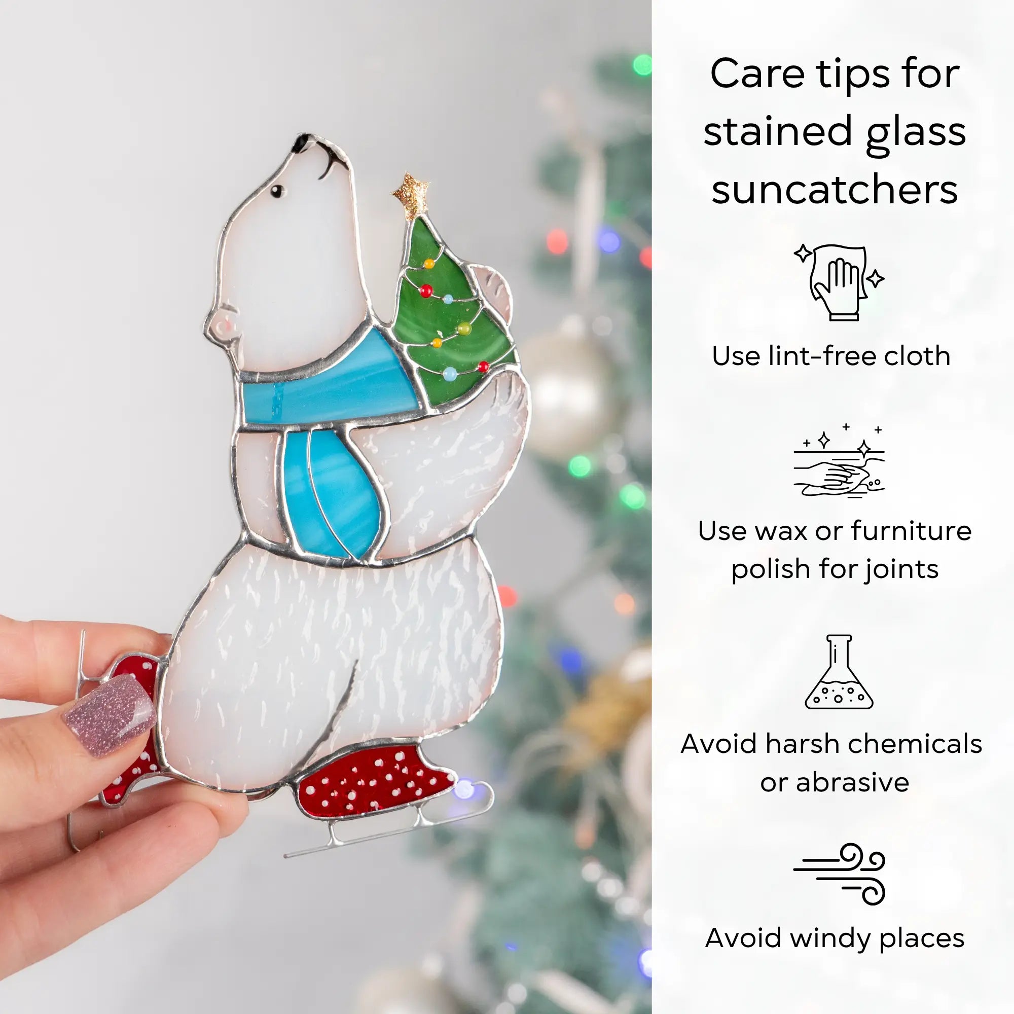 Stained glass suncatcher featuring a polar bear holding a Christmas tree, held by a hand with care tips on the right: use lint-free cloth, polish joints with car wax or furniture polish, avoid harsh chemicals, and windy places.