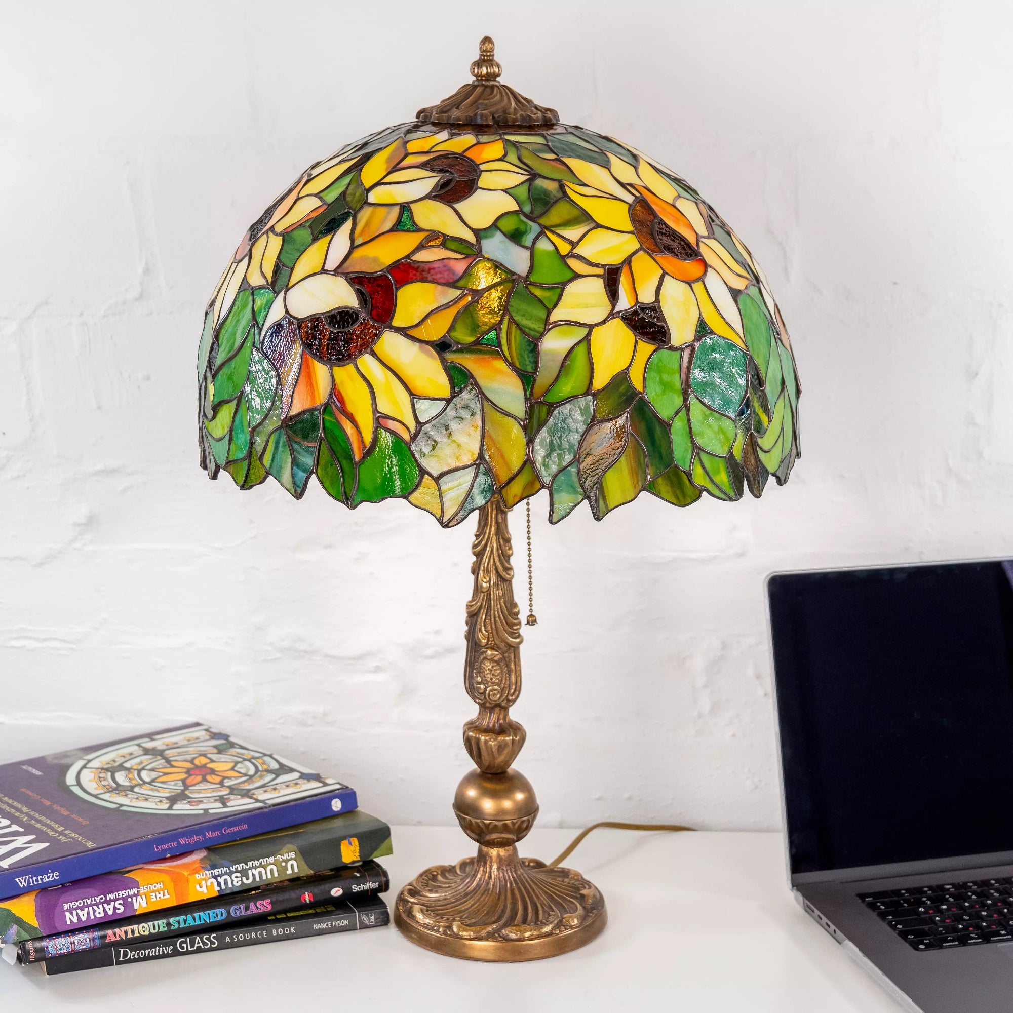 Stained glass sunflower lamp used as cozy desk lighting next to books