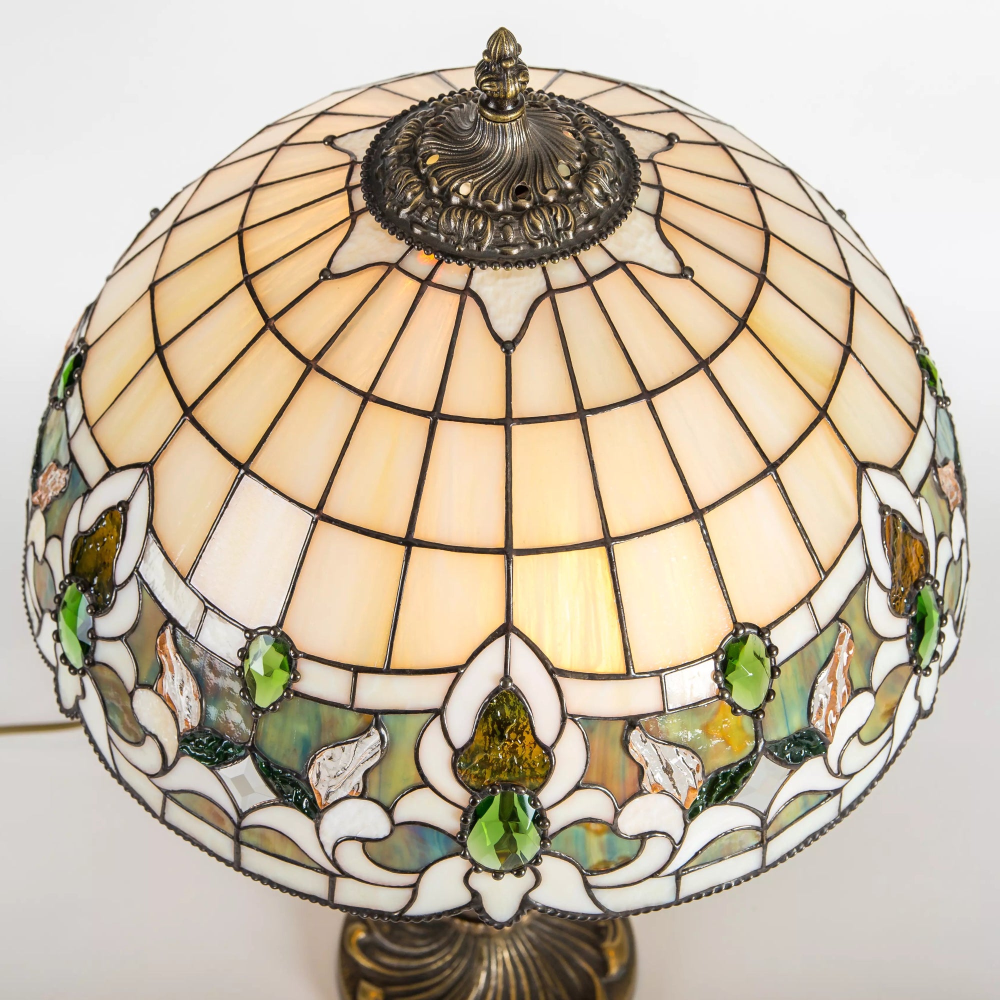 Overhead view of stained glass lamp showing layout of warm-toned and green floral panels