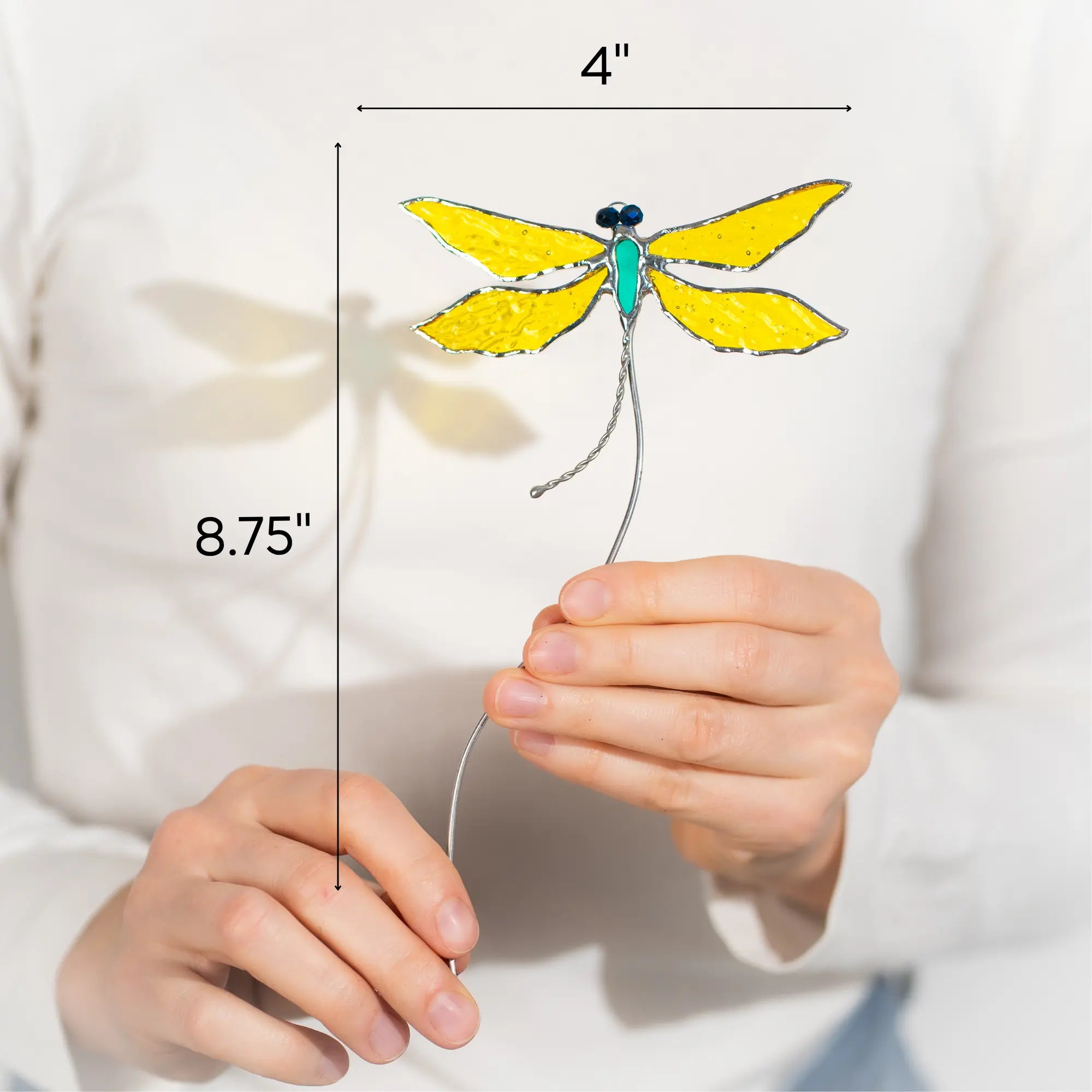 Yellow dragonfly stained glass plant stake held by hands with measurements indicated 4 x 8.75 inches