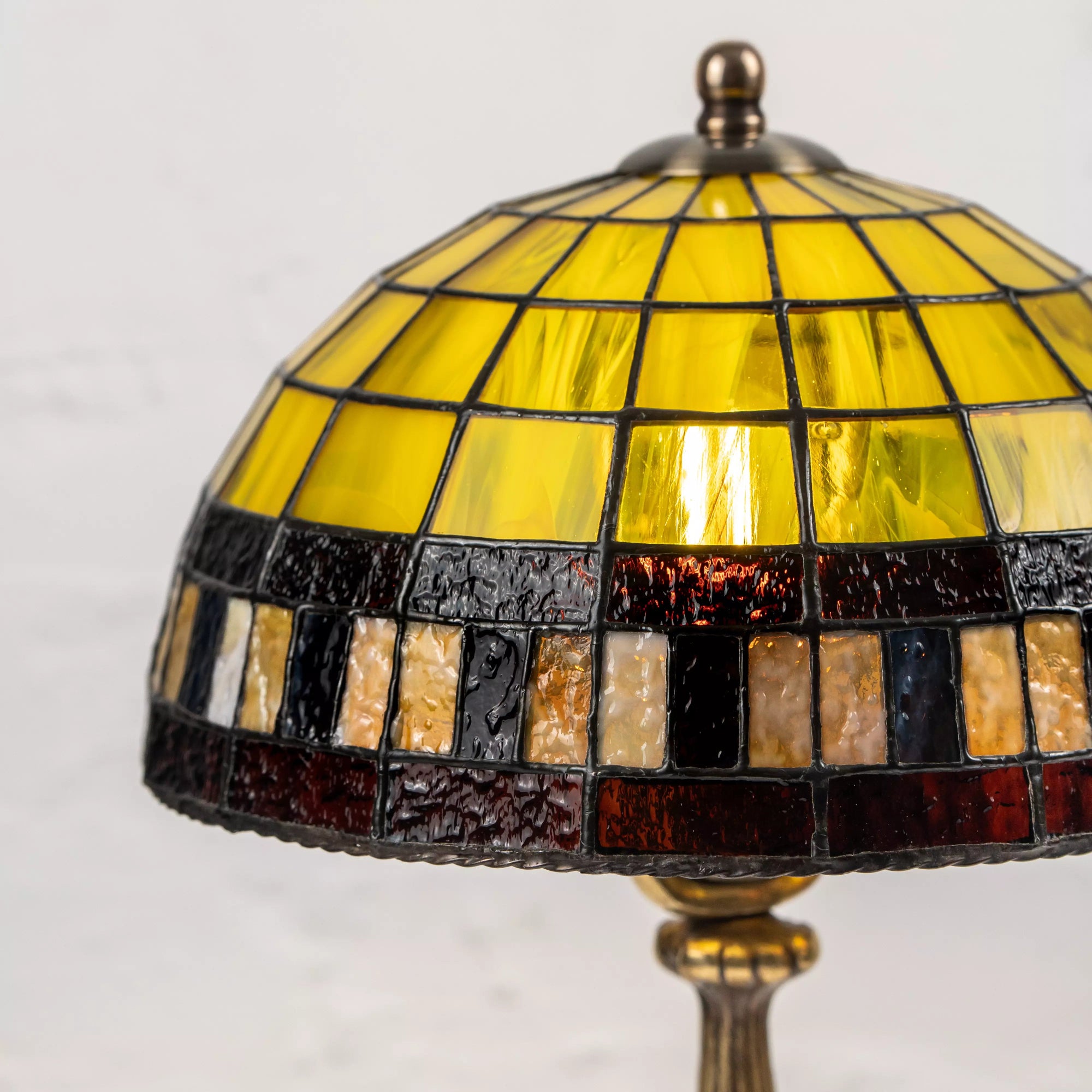 Detailed stained glass dome showing yellow segments and textured amber-black glass border