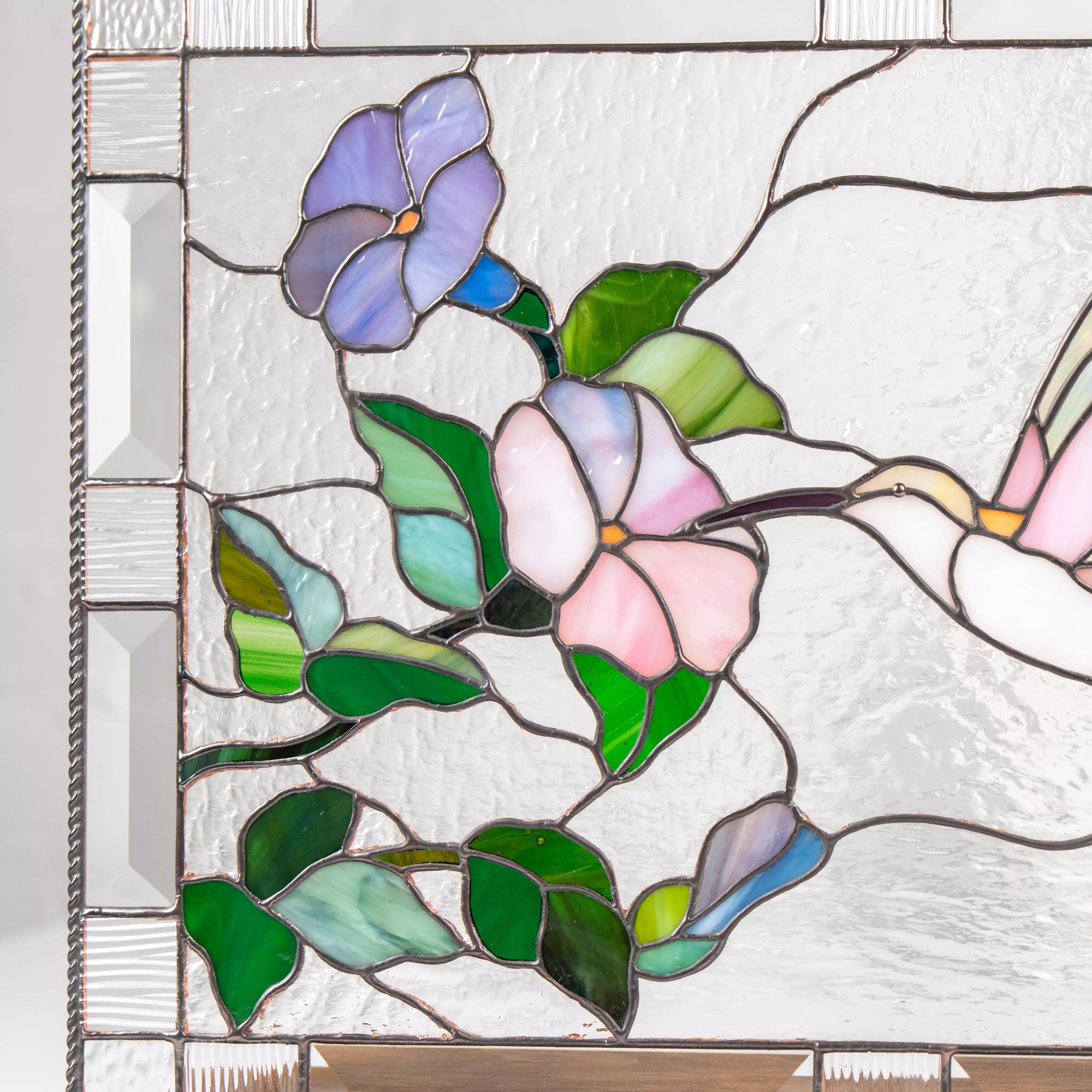 Stained glass panel with floral design featuring pink, purple, and green flowers.
