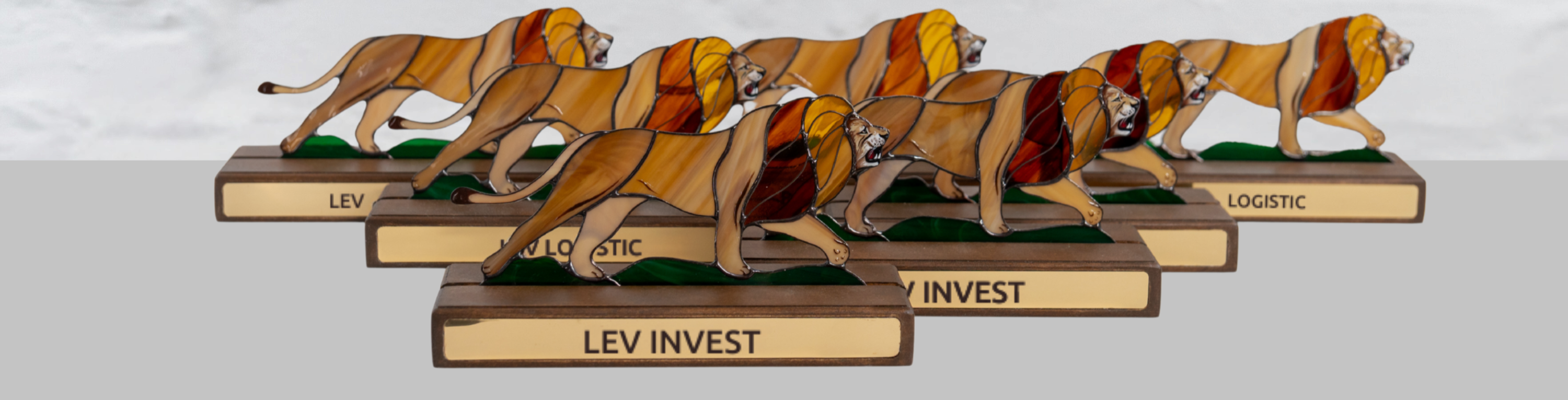 Stained glass lion sculptures with labels LEV INVEST or LEV LOGISTIC