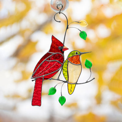 Red winter bird and green hummingbird window hanging of stained glass
