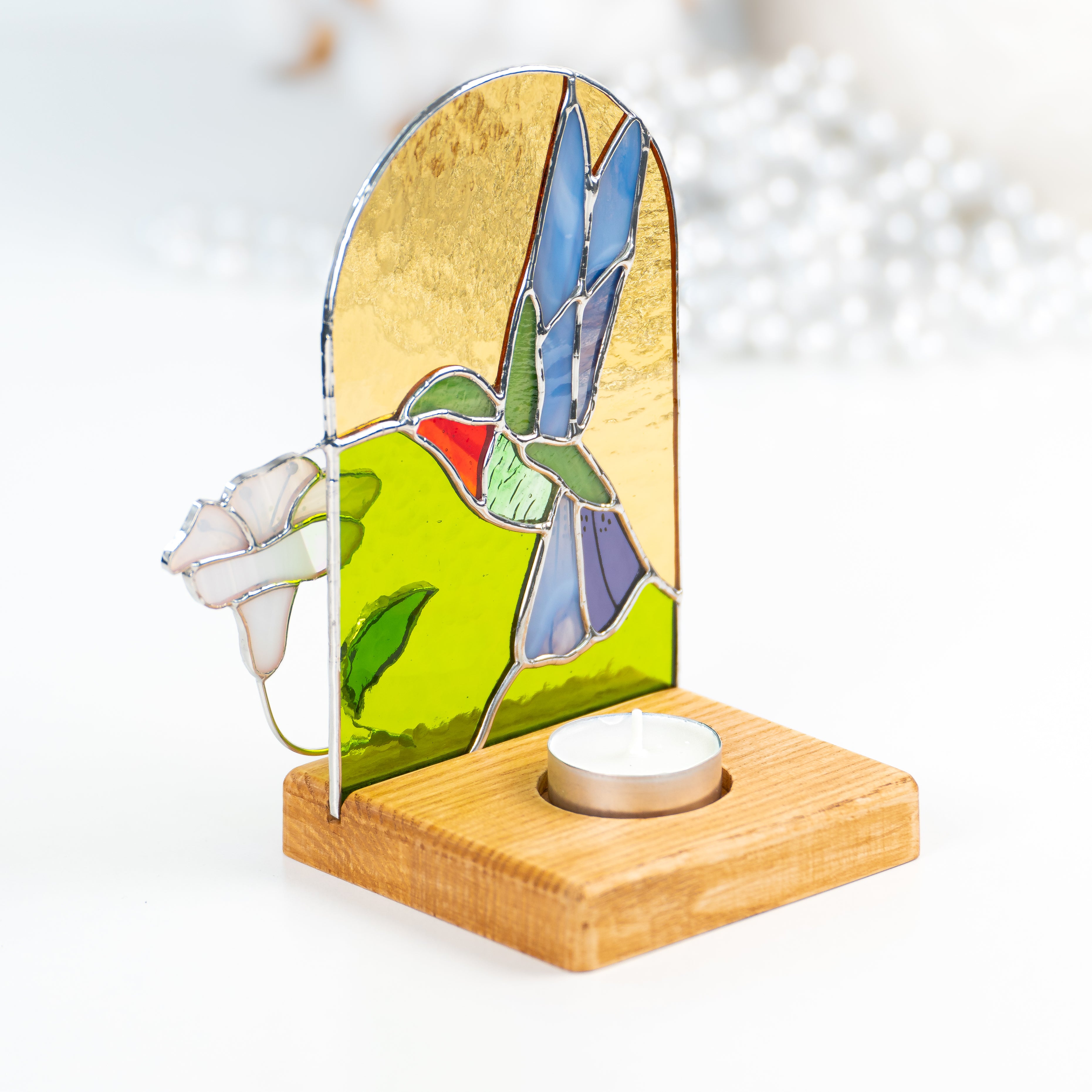Candle-lit stained glass panel in a wooden base from behind