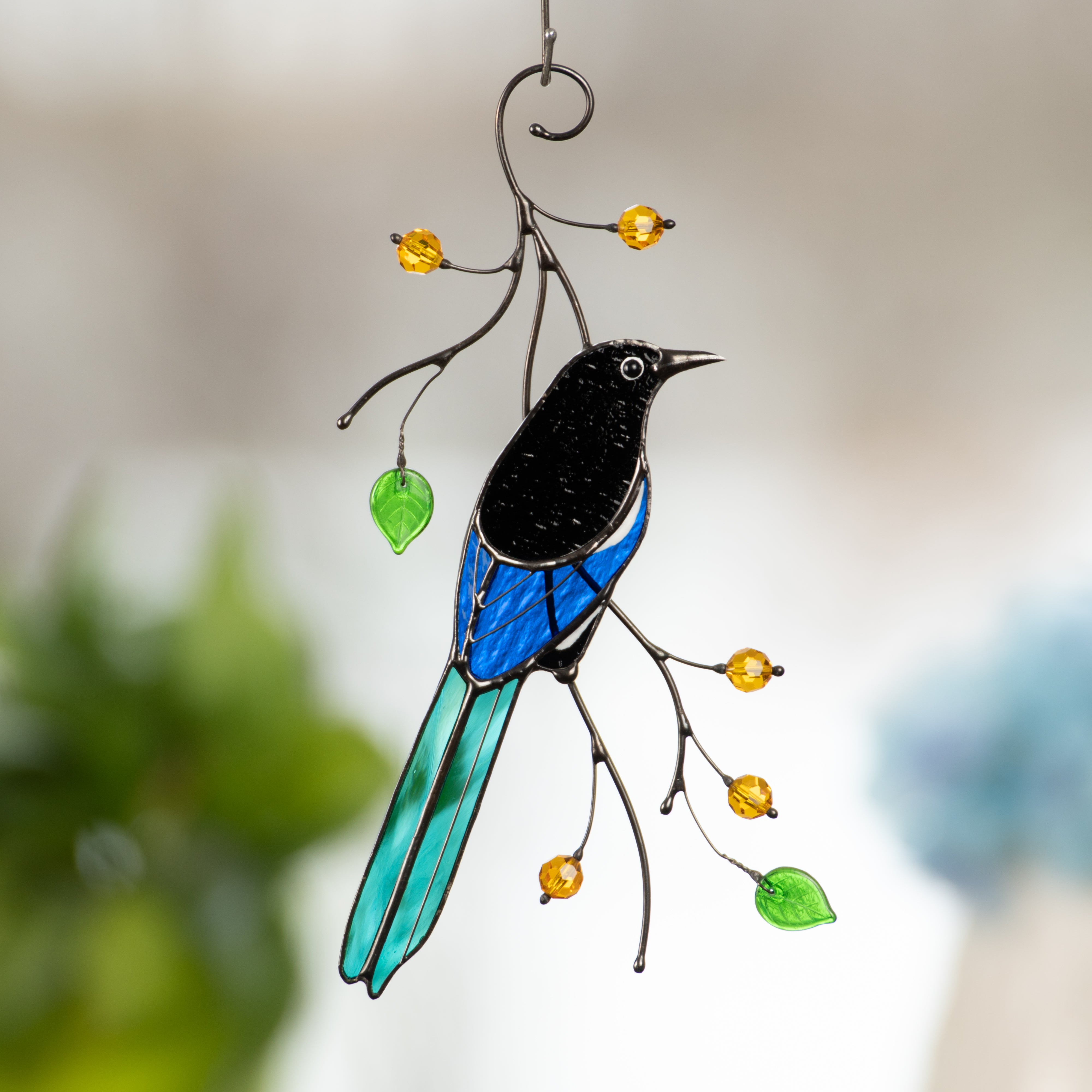 Back-view magpie on the branch with leaves and berries suncatcher of stained glass