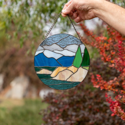 Round panel depicting Lake Tahoe of stained glass