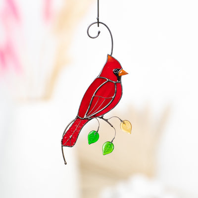 Stained glass red cardinal on the branch with leaves suncatcher