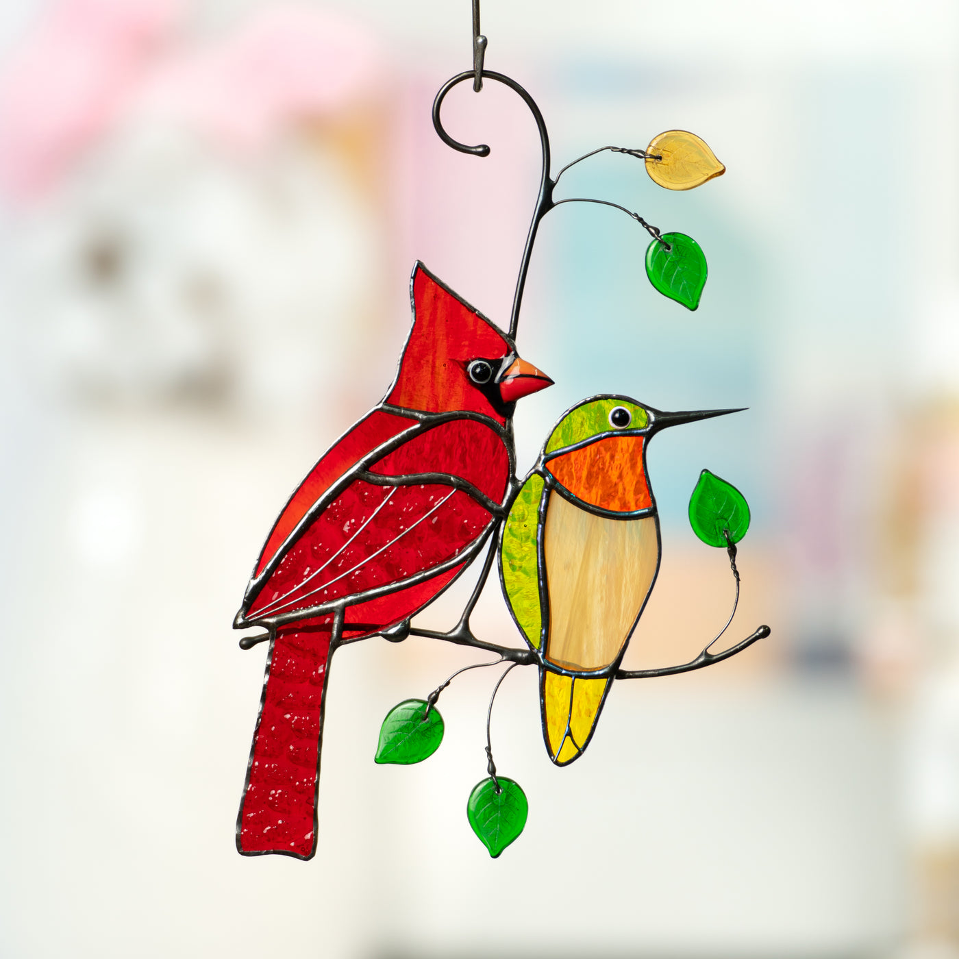 Red cardinal and green hummingbird sitting on the branch suncatcher of stained glass