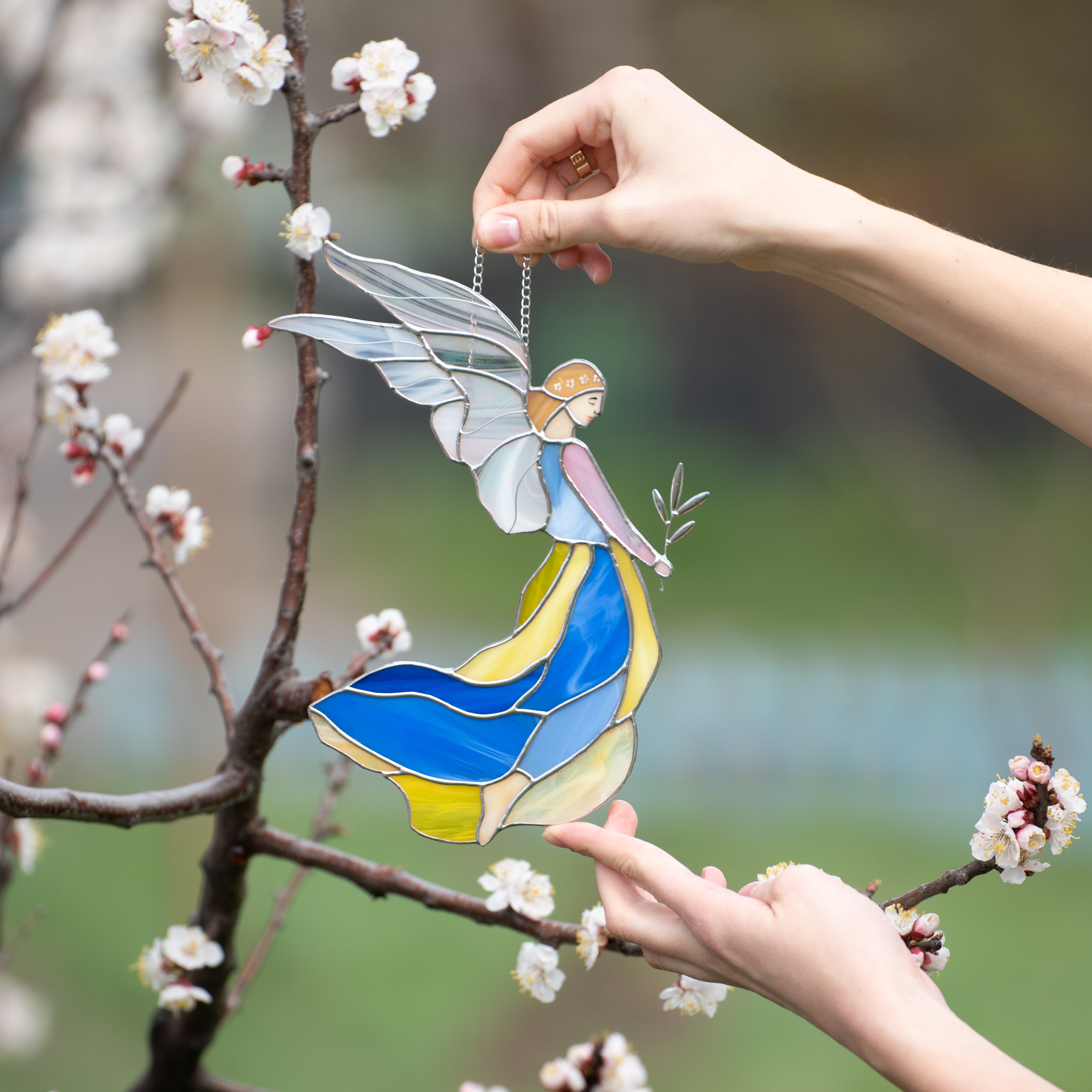 Girl guardian angel in blue and yellow dress with iridescent wings suncatcher of stained glass