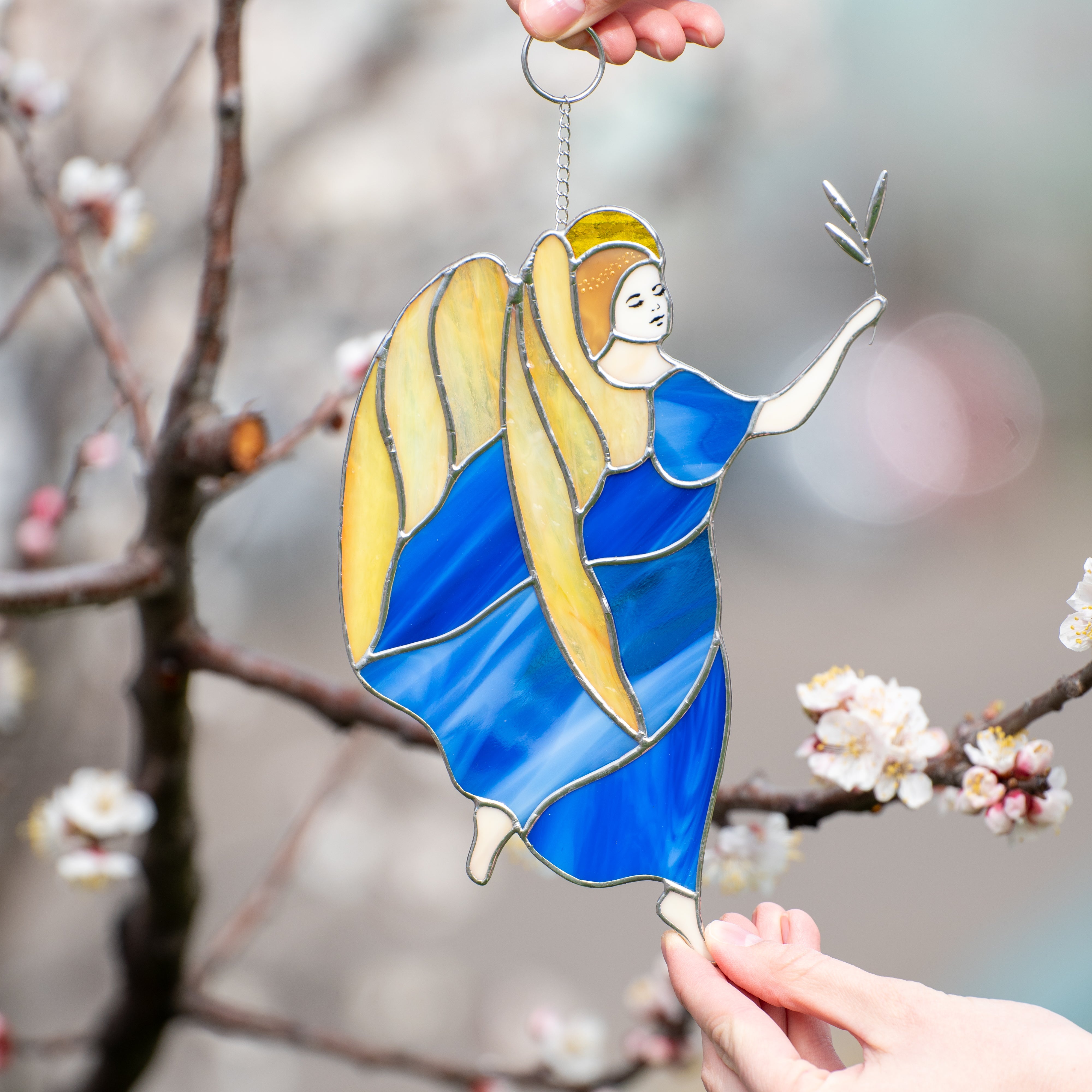Stained glass guardian angel with yellow wings wearing a blue dress suncatcher
