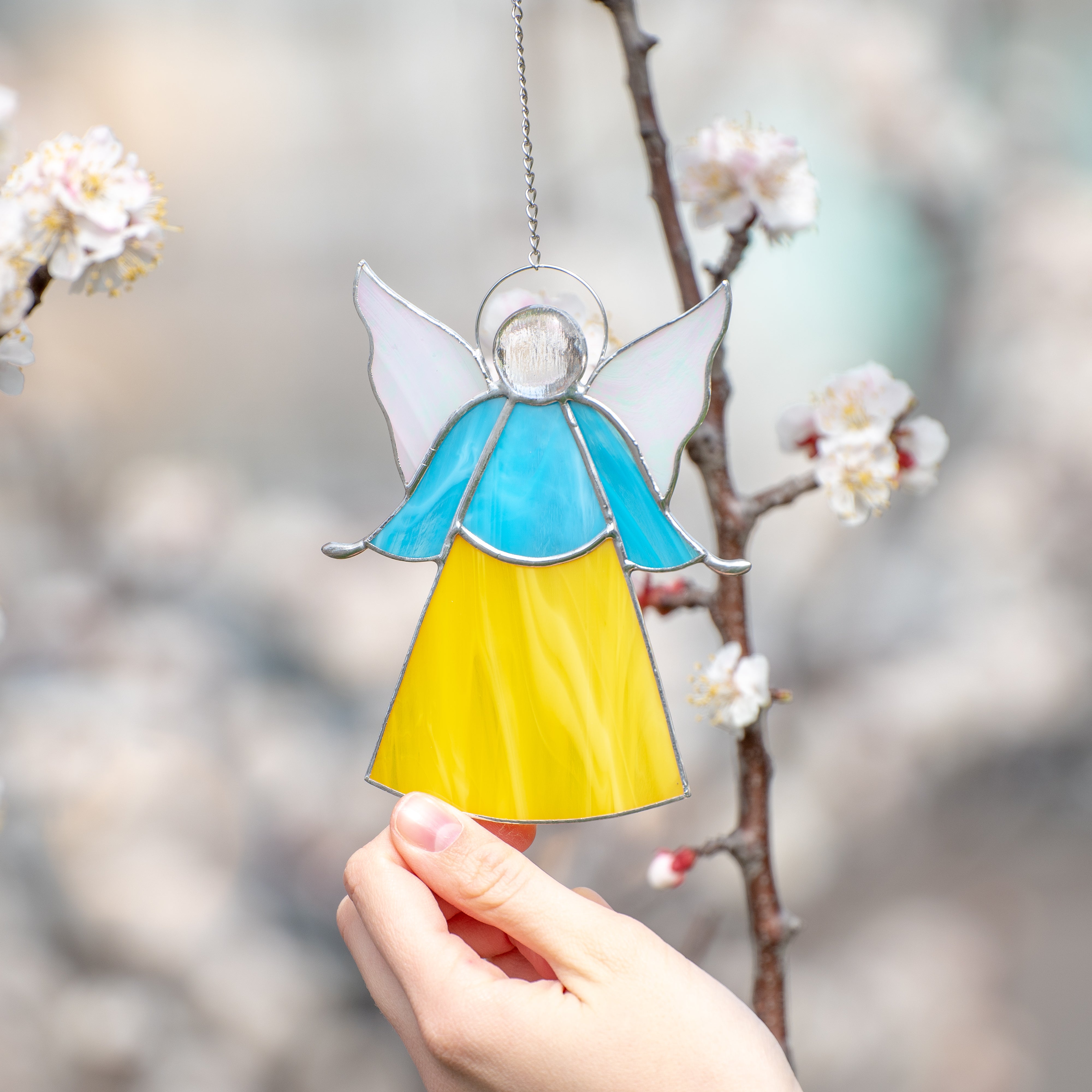 Stained glass angel suncatcher of blue above and yellow color below