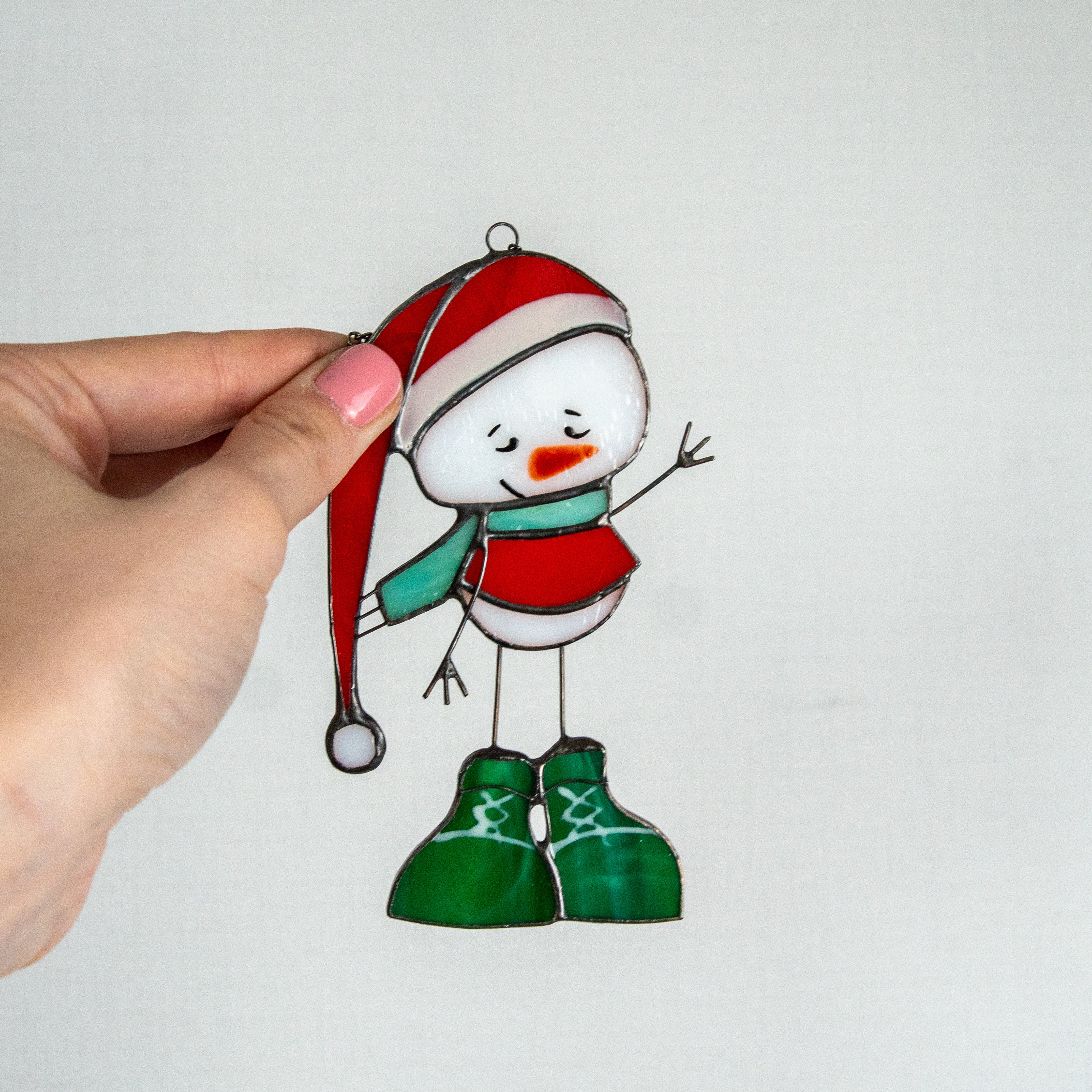 Stained glass snowman wearing a red hat and green boots suncatcher
