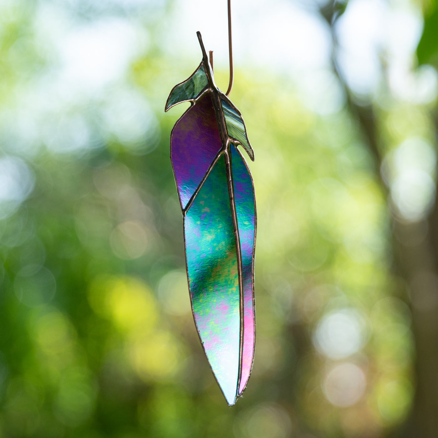 Window hanging of a stained glass raven feather for decor