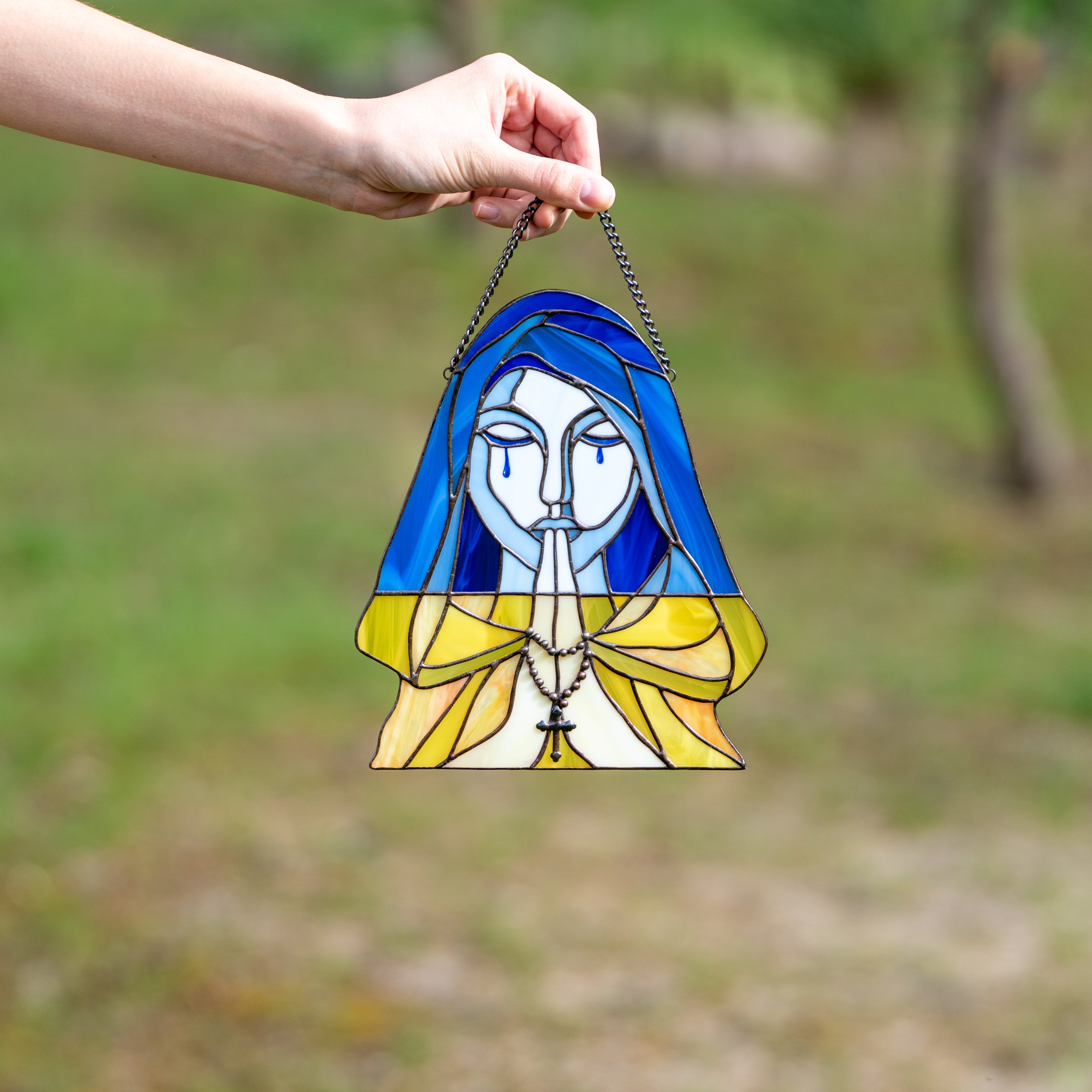 Stained glass praying and crying woman symbolising Ukraine window panel