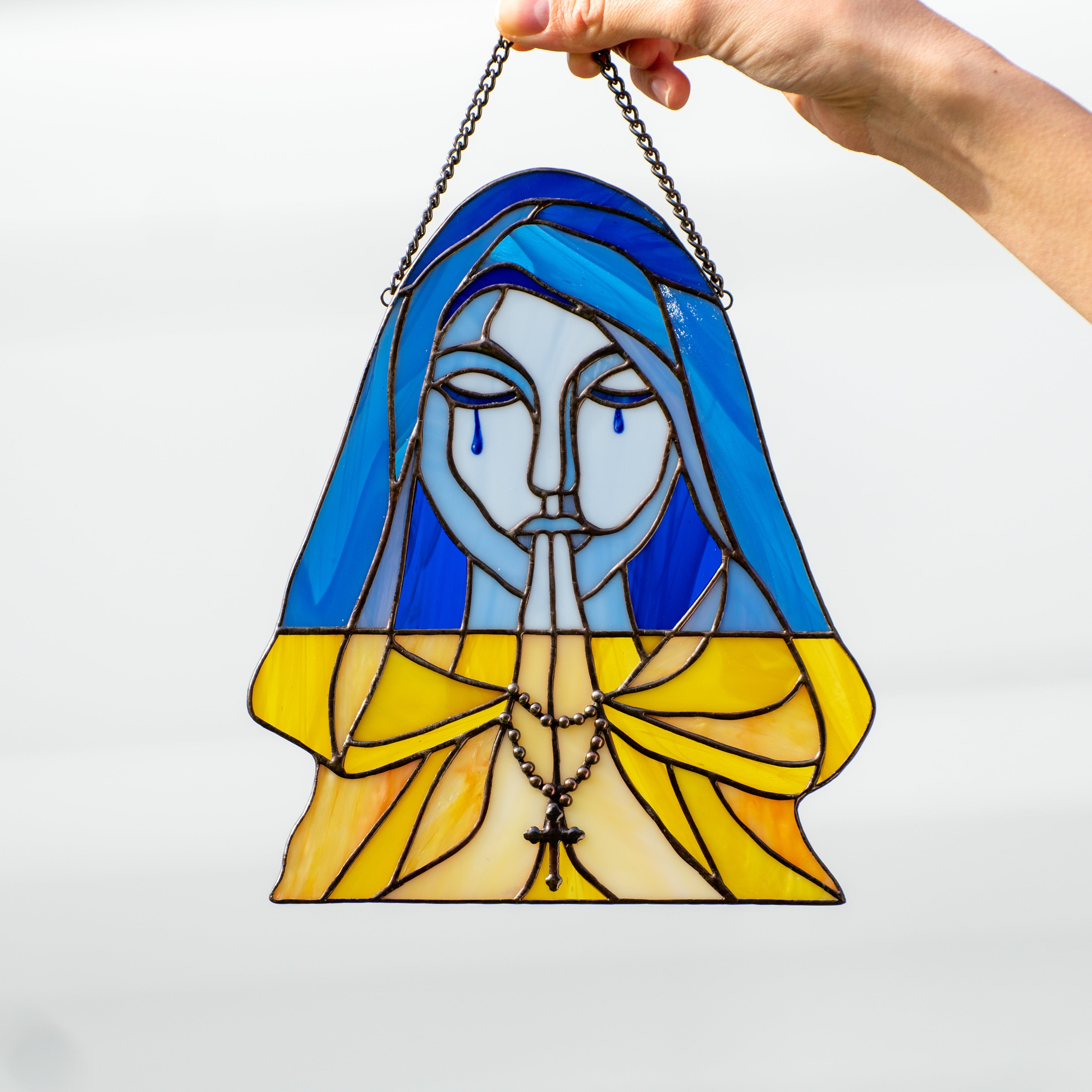 Stained glass praying and crying woman symbolising Ukraine window hanging