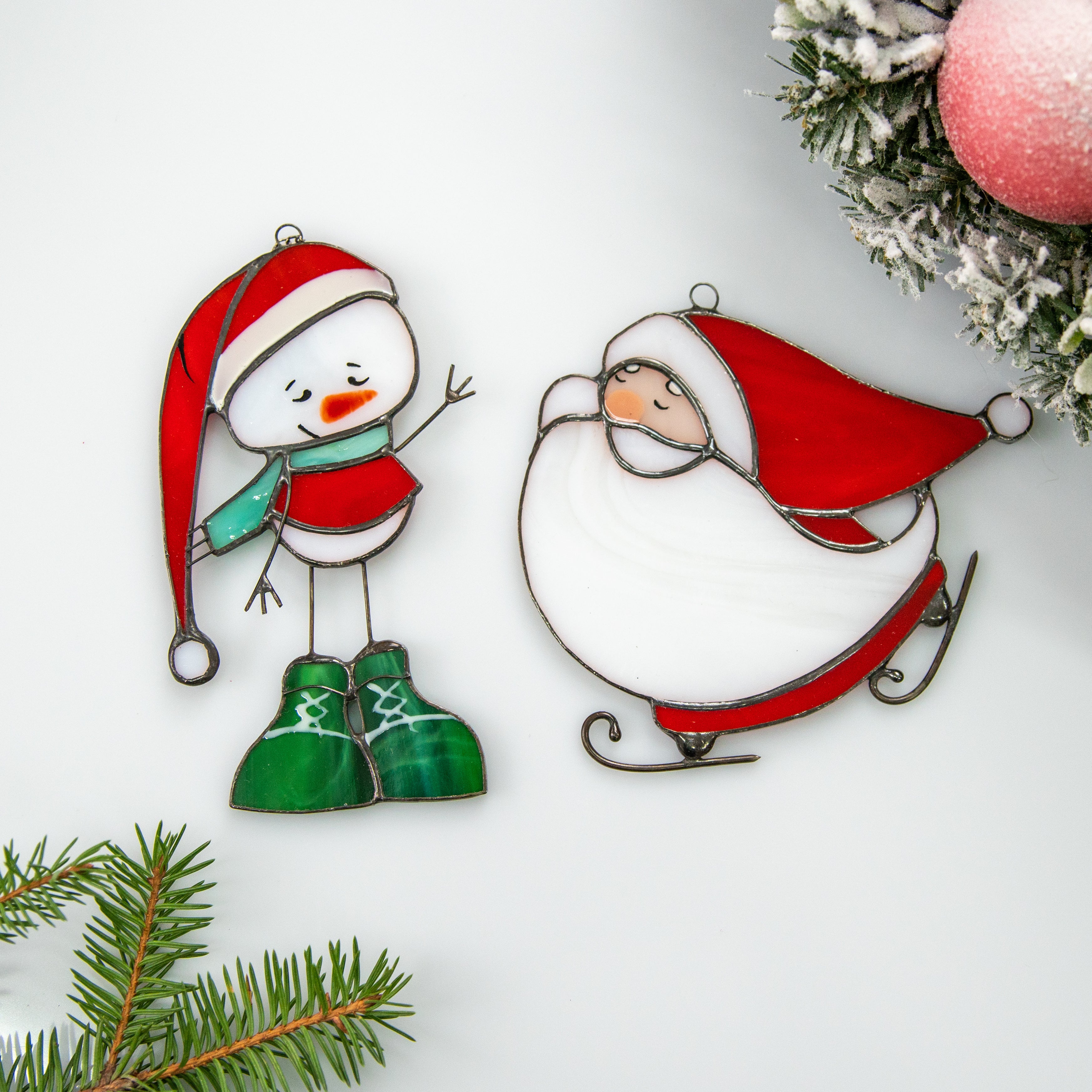 Two stained glass suncatchers of a snowman and santa Edit alt text