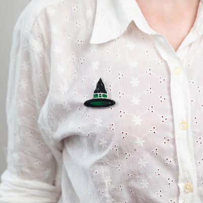 Witch hat pin of stained glass on a white shirt