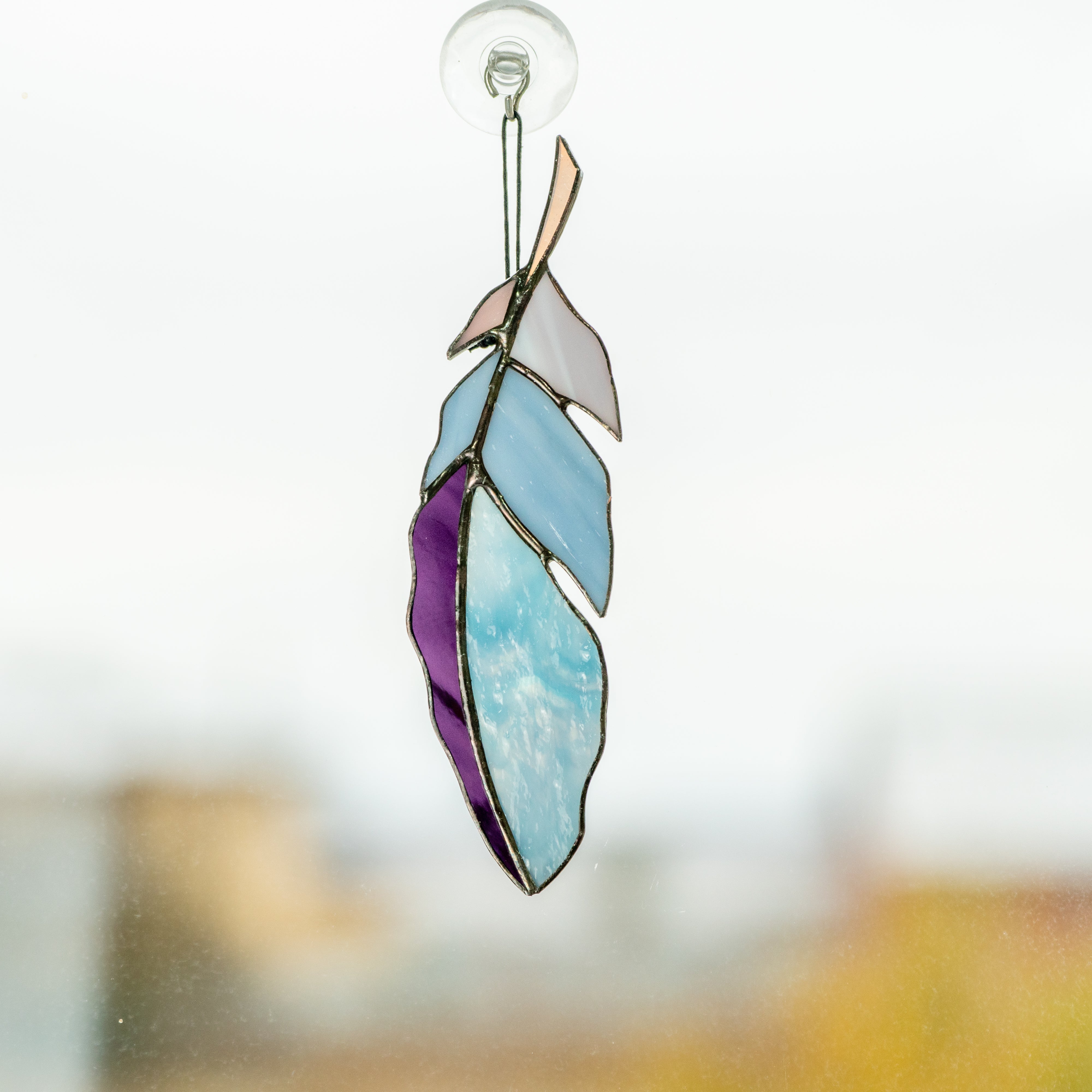 Blue feather suncatcher with shades of purple of stained glass