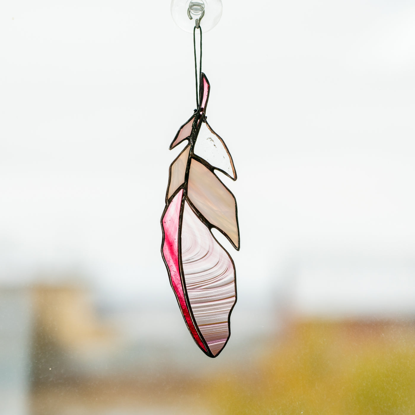 Pink with its shades stained glass feather suncatcher