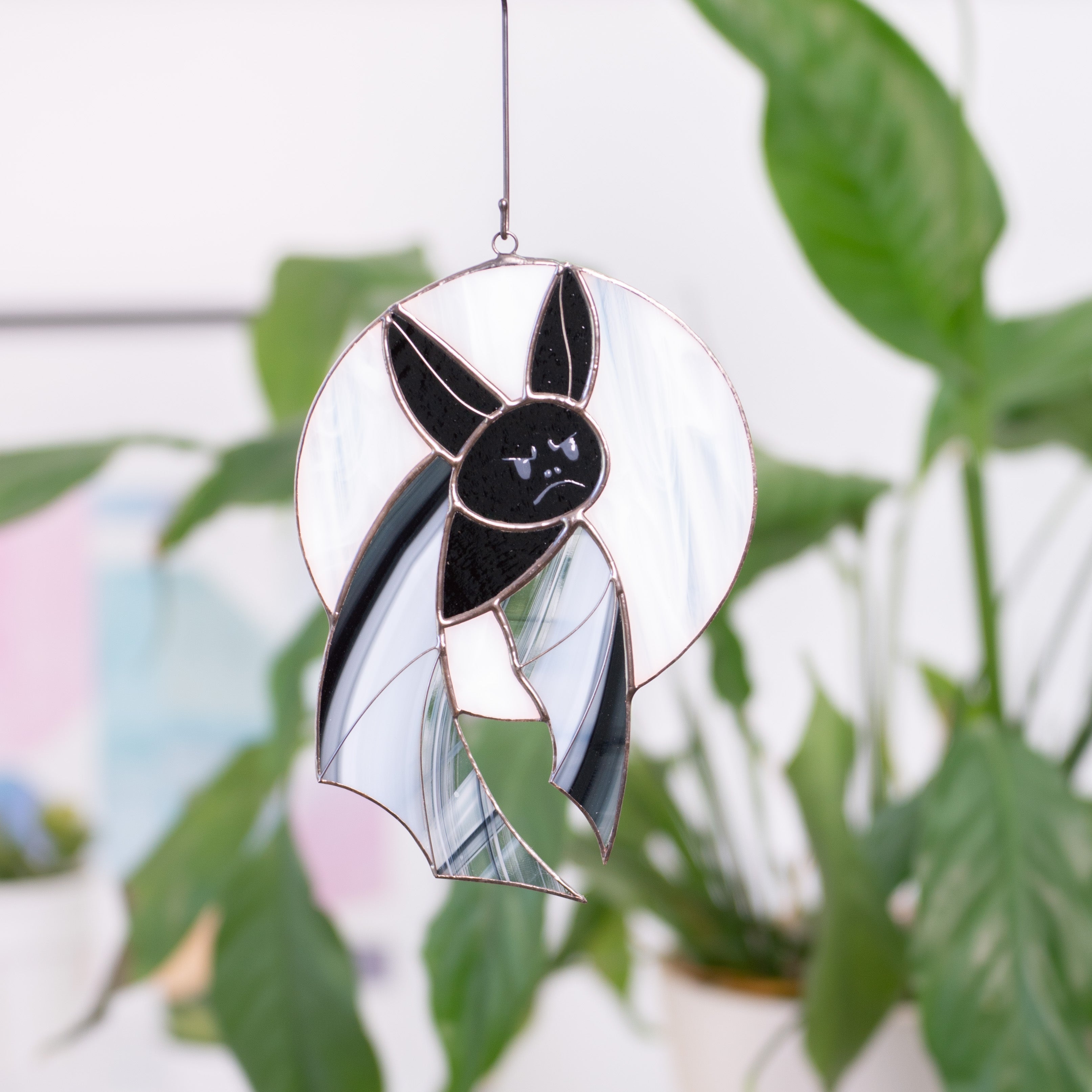 Stained glass Halloween suncatcher of a bat on the white moon