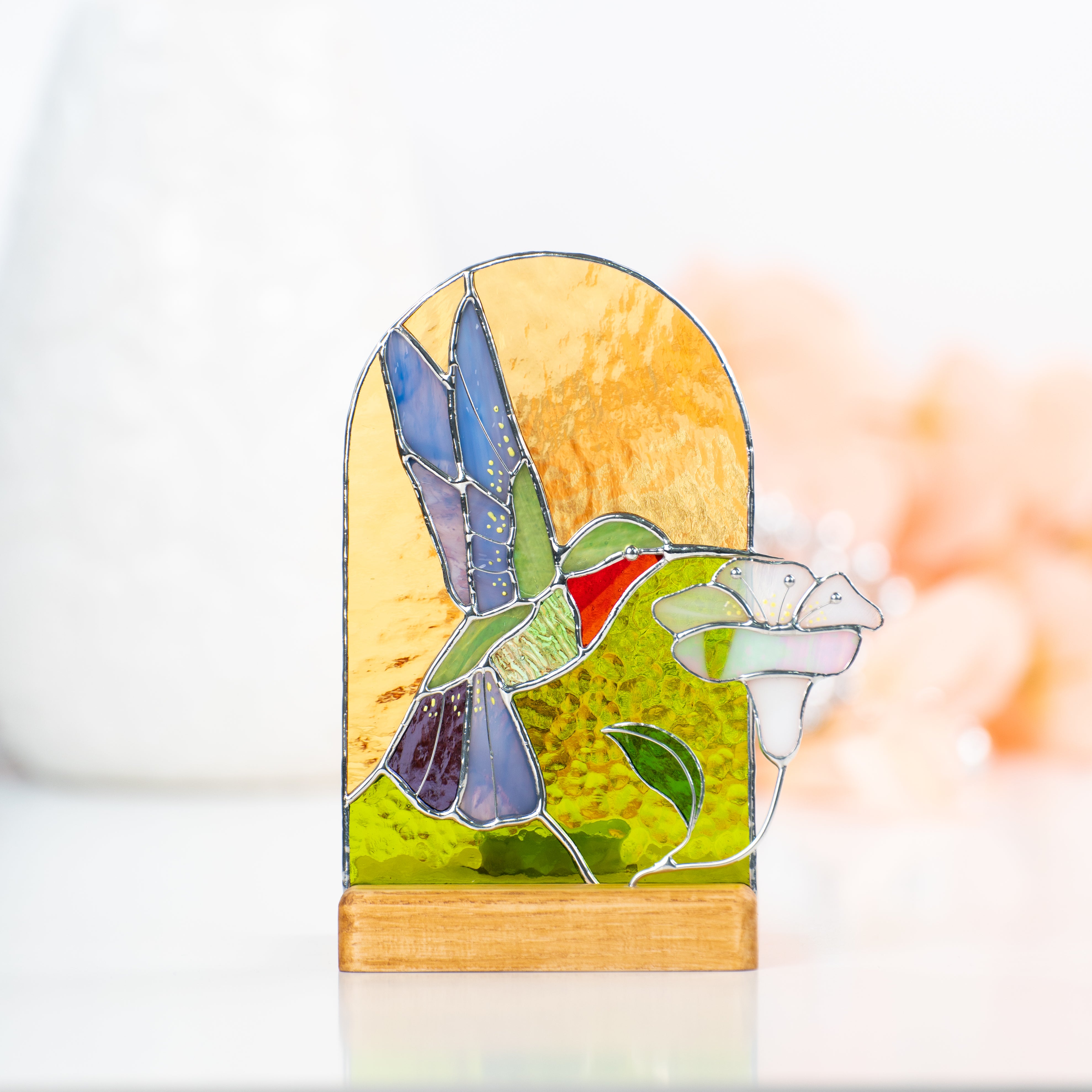 Zoomed stained glass panel in a wooden base depicting hummingbird