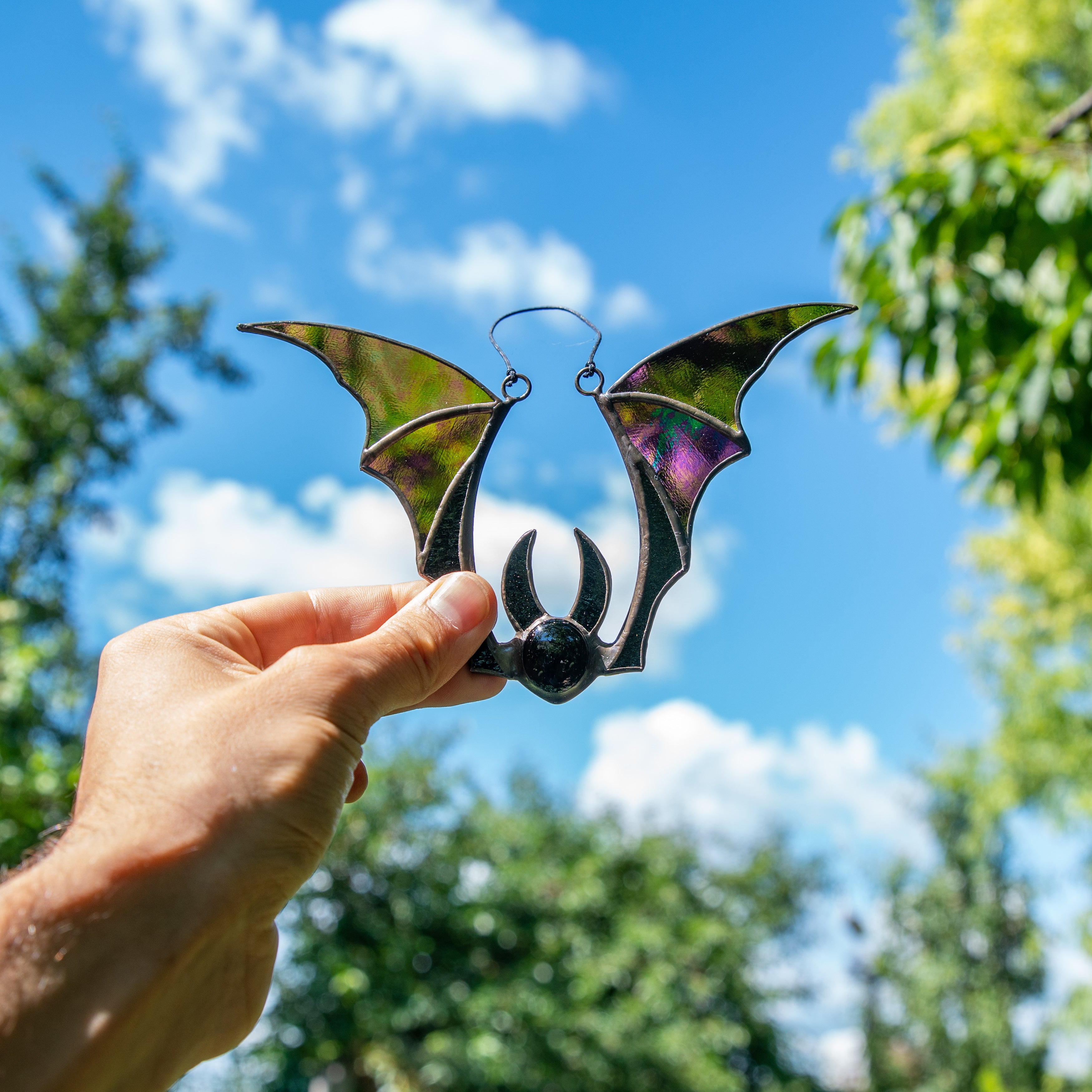 Window hanging of a stained glass bat with iridescent wings