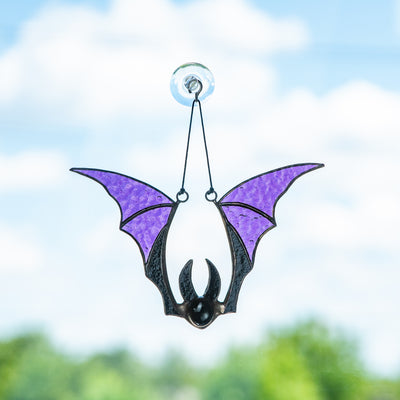 Stained glass suncatcher of a purple-winged bat for Halloween