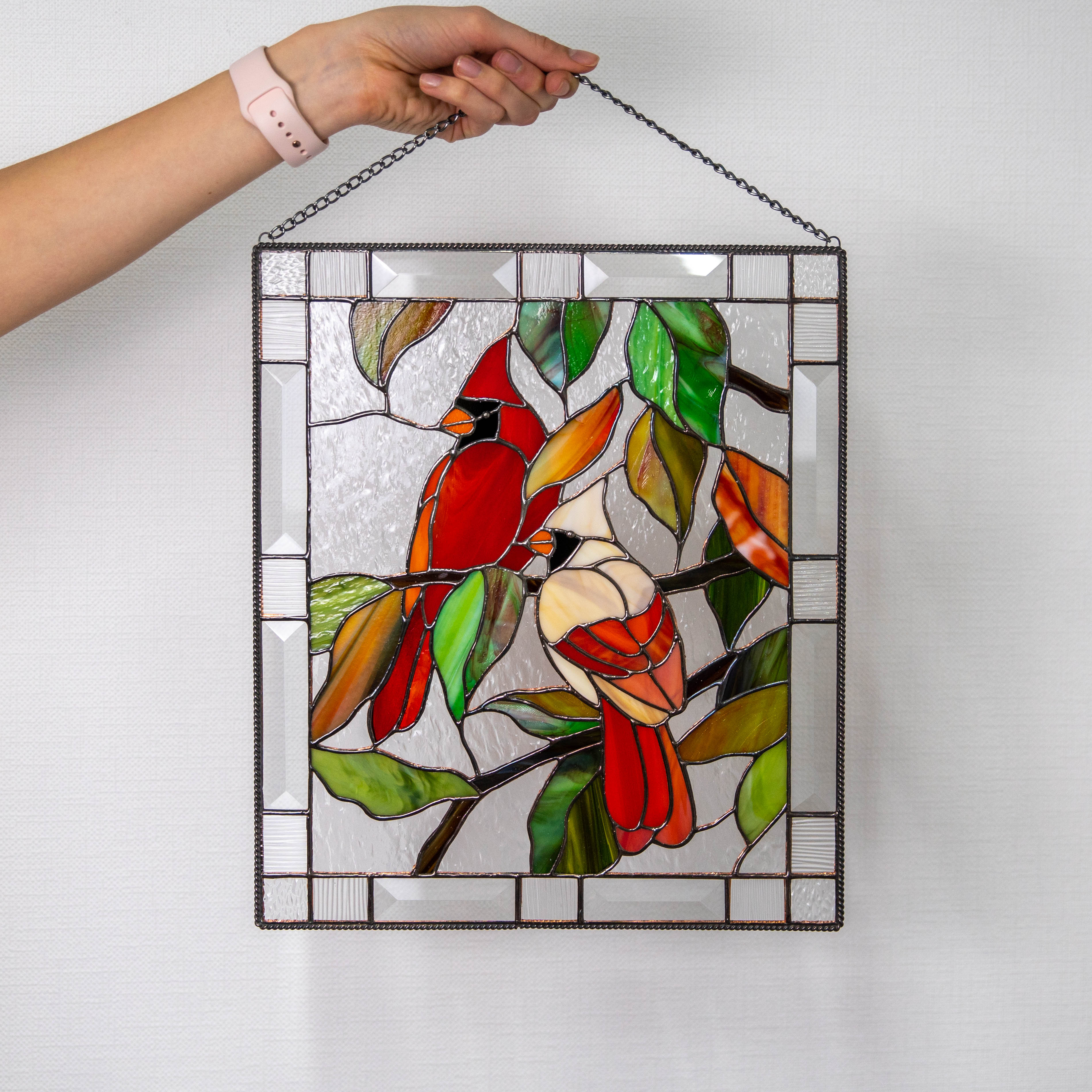 Stained glass window panel depicting a couple of cardinals sitting on the branch