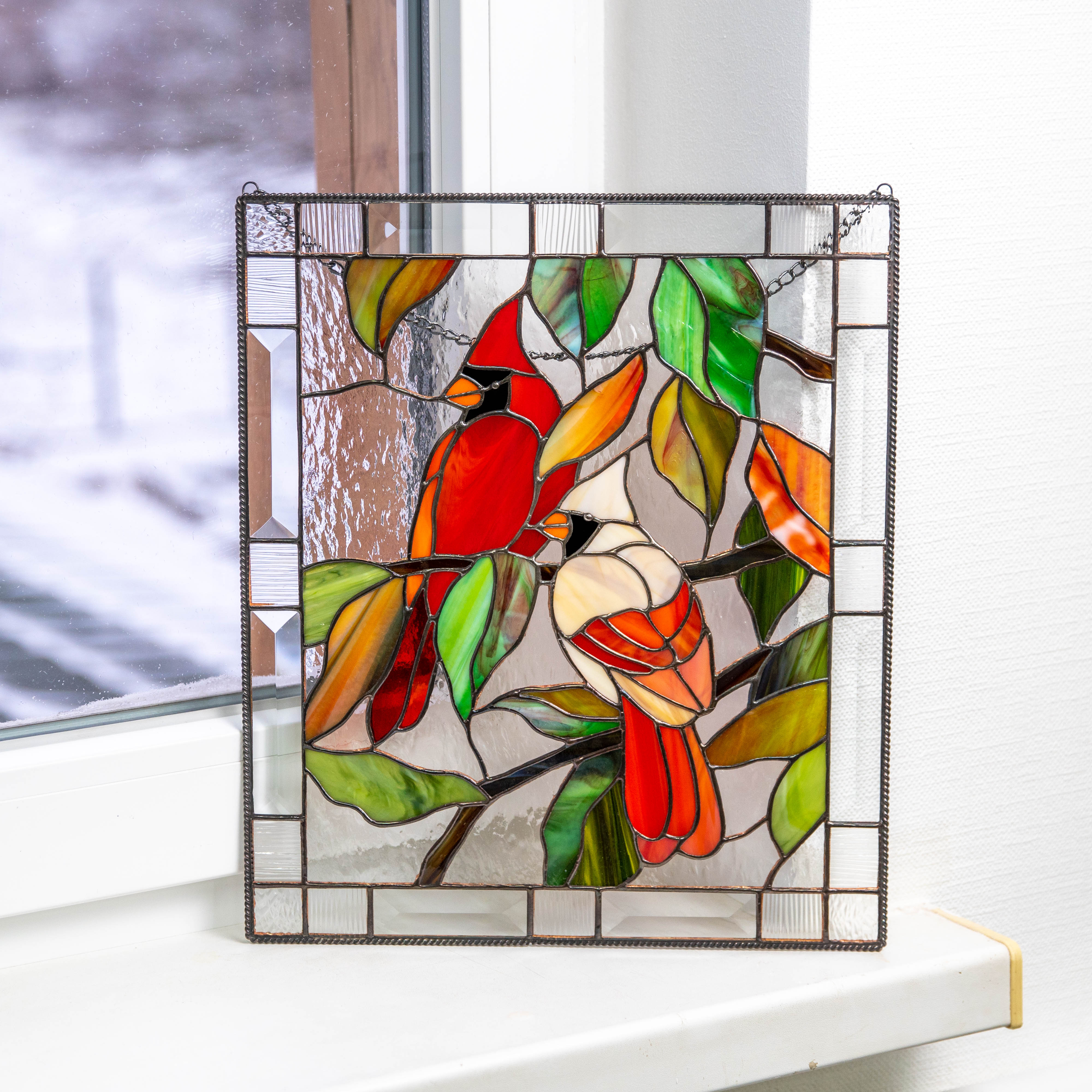 Stained glass window hanging depicting a couple of cardinals