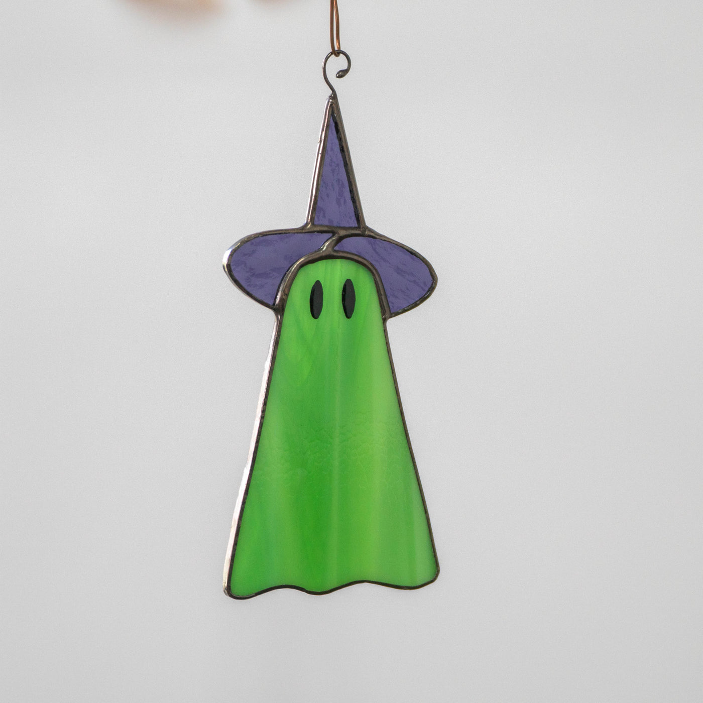 Green stained glass ghost in purple hat suncatcher for Halloween decor