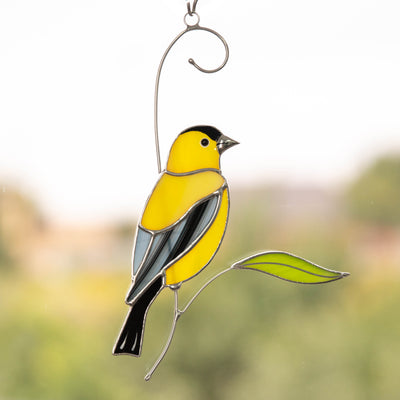 Bright stained glass goldfinch on the branch suncatcher