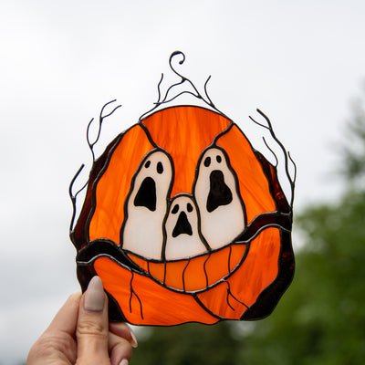 Stained glass pumpkin with ghost-eyes window hanging for spooky Halloween decor